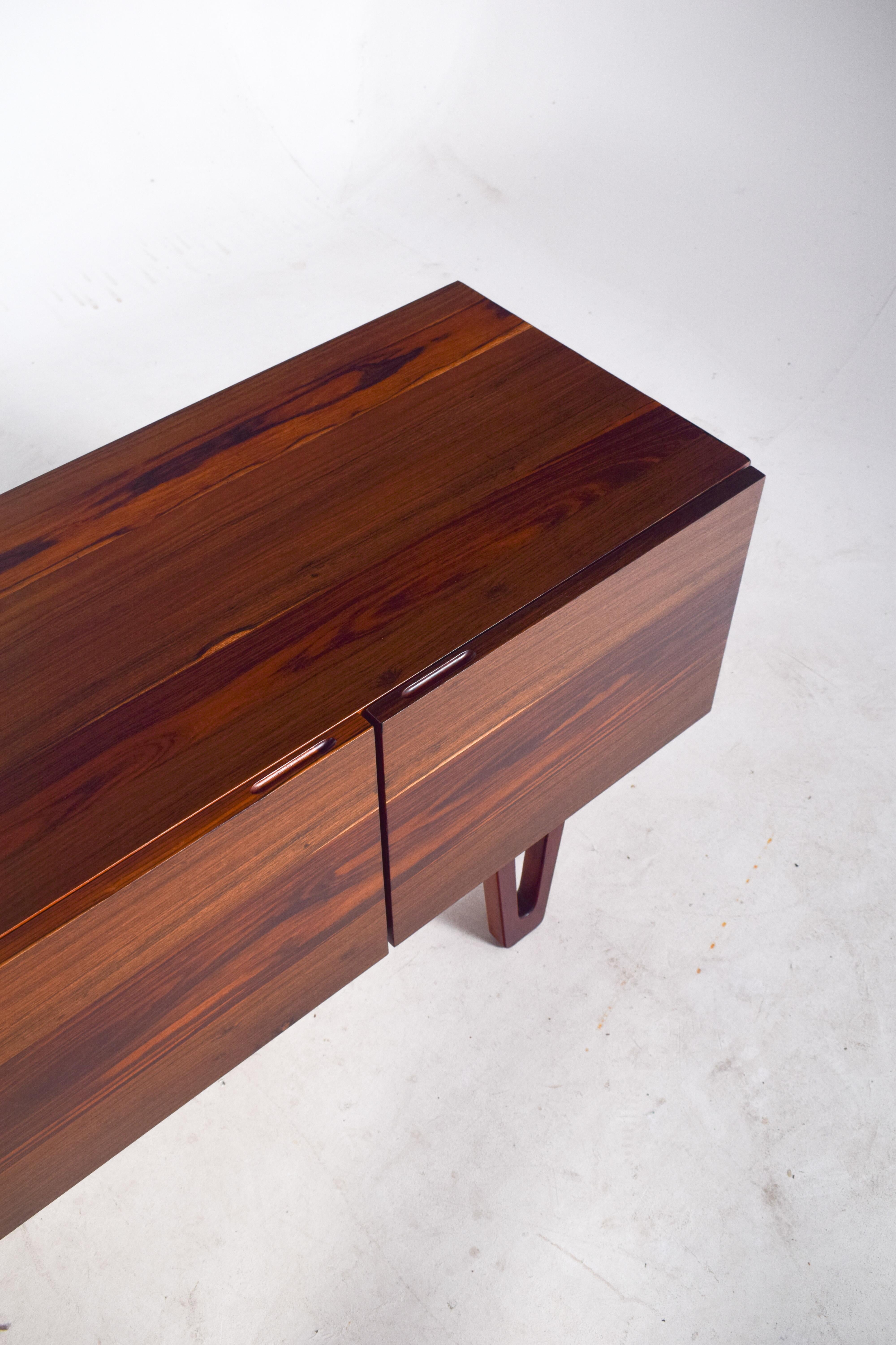 Ce magnifique buffet en bois de rose, fabriqué par Dustwood Portugal en 2025, est une pièce en édition limitée, faisant partie d'une série exclusive de sept exemplaires seulement. Conçu avec un grand souci du détail, le buffet présente un placage de