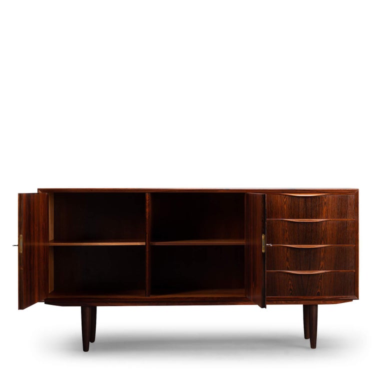 Minimalist Danish rosewood design sideboard by Erling Torvits and produced by Klim Møbelfabrik. Made from a beautiful dark palissander. The organic design of the drawers give this sideboard a stylish look. Because the sideboard has become slightly