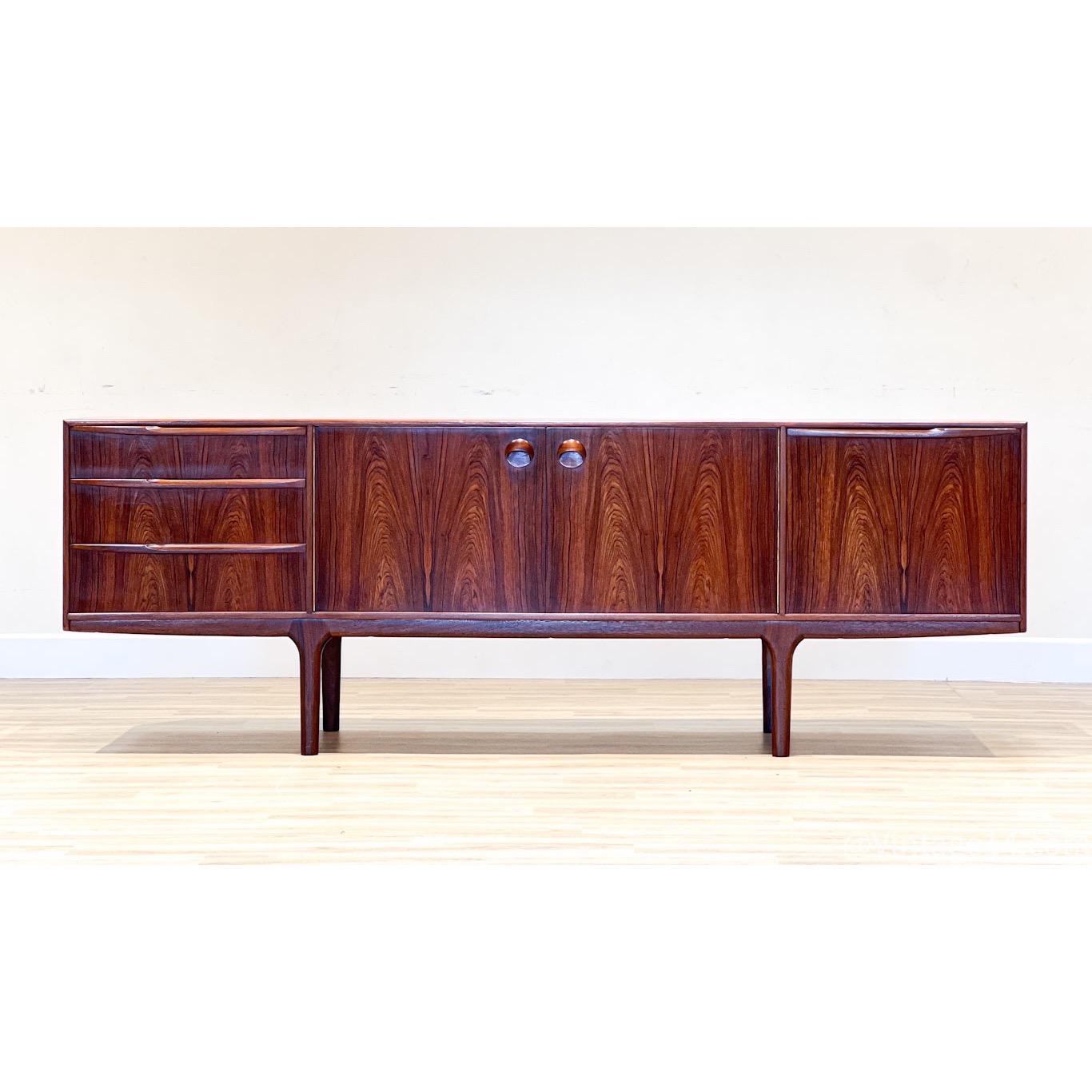Tom Robertson designed this sideboard for its collection Dunfermline in Scotland for the high-end cabinet maker A.H. McIntosh. The sideboard, handcrafted in stunning rosewood, has all its original features.
This sideboard belongs to one of its