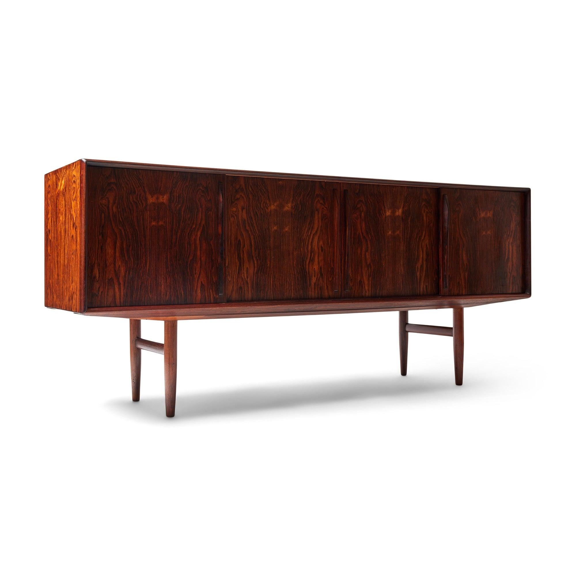 Una credenza in palissandro progettata dal designer danese Kurt Östervig. Si tratta di un ampio mobile contenitore con ante scorrevoli, un ampio spazio di archiviazione, con cassetti in legno di palissandro in uno scomparto e scaffali aperti negli