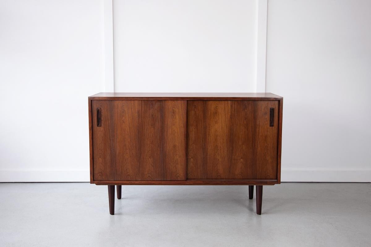A beautiful rosewood sideboard from Denmark featuring wonderfully patterned rosewood and elegant inset handles. The sliding doors reveal internal storage with adjustable shelves and a single drawer. 

Dimensions: Width 120cm / Depth 45cm / Height