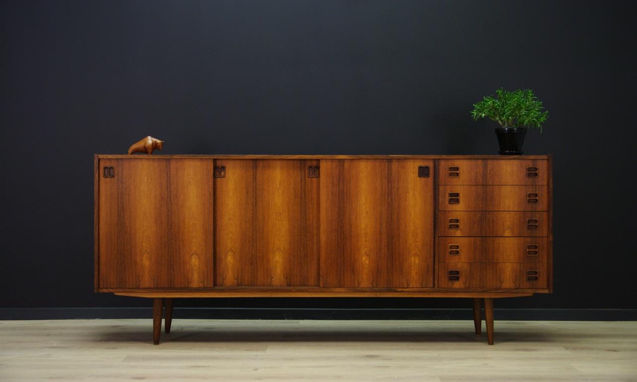 Fantastic sideboard from the 1960s-1970s, minimalist form finished with rosewood veneer. Roomy interior with shelves behind the sliding door. The sideboard also has five drawers. Preserved in good condition (small dings and scratches) - directly for
