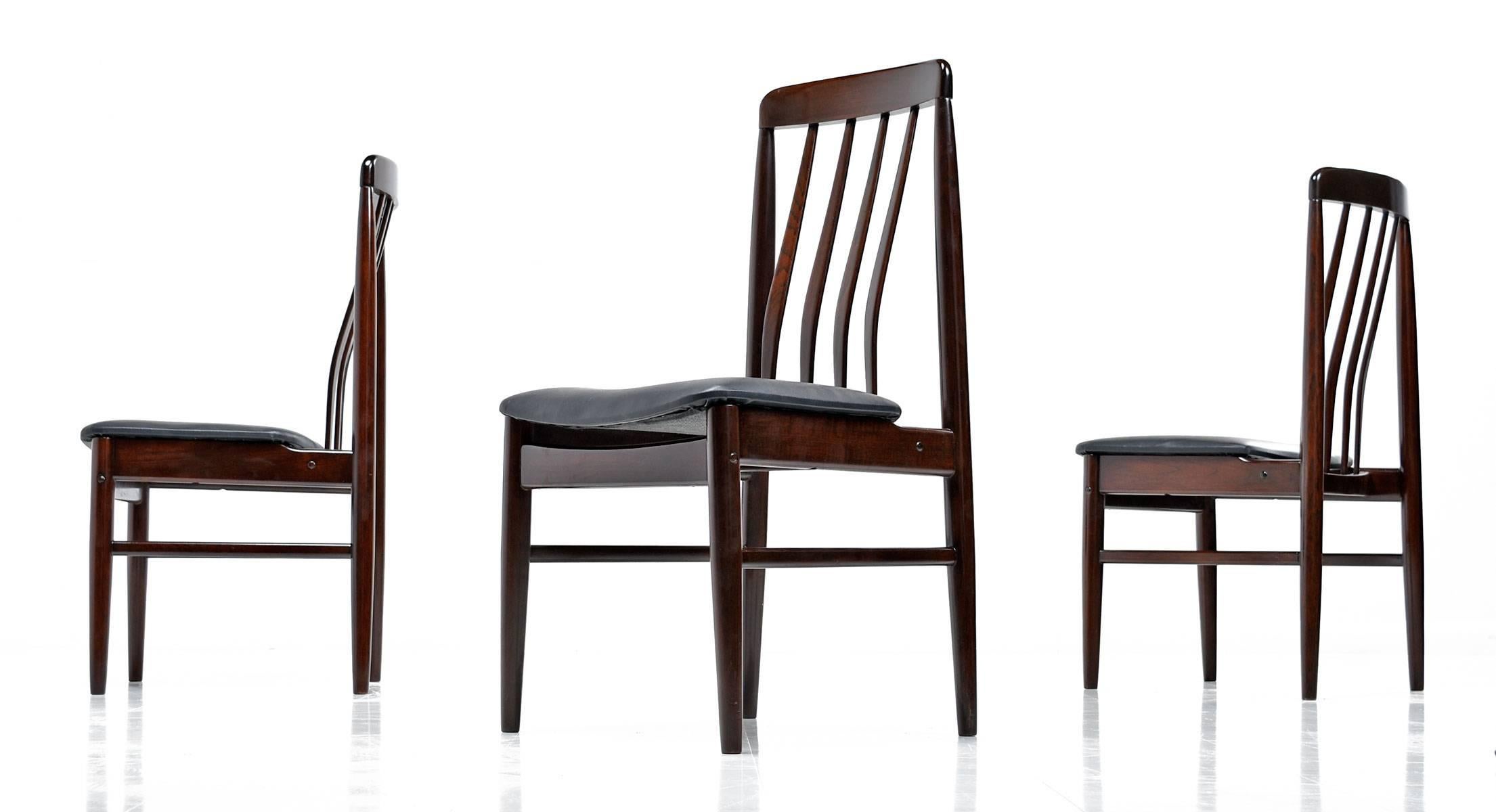 Outstanding set of four Danish Modern rosewood dining chairs. One does not have to sacrifice comfort for style. These chairs embrace your back with their contoured, ergonomic design. The chairs have been restored with all new high quality black