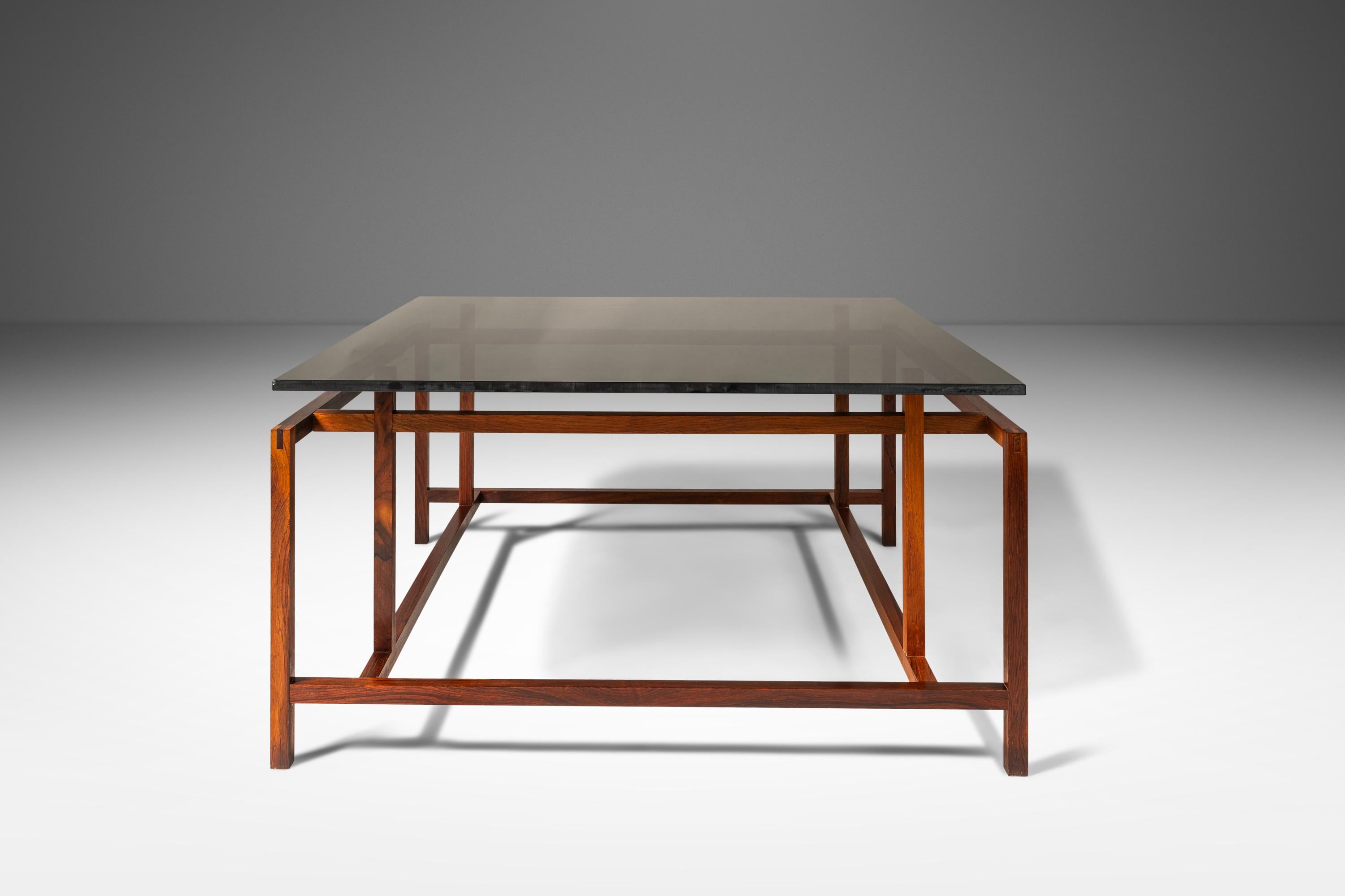  Introducing a rare floating top coffee table designed by Henning Nørgaard for Komfort of Denmark that is as iconic as it is architecturally fascinating. Constructed from solid Brazilian Rosewood the elegantly-designed frame is both simple and