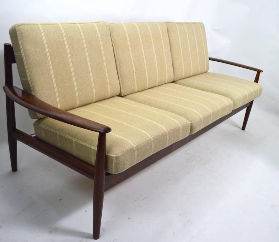 Wonderful rosewood Danish modern sofa designed by Grete Jalk for France and Son. This example is completely original, clean and ready to use. Truly an iconic example from the Golden Age of Modern Danish furniture. Measures: Arm height 21 inches x