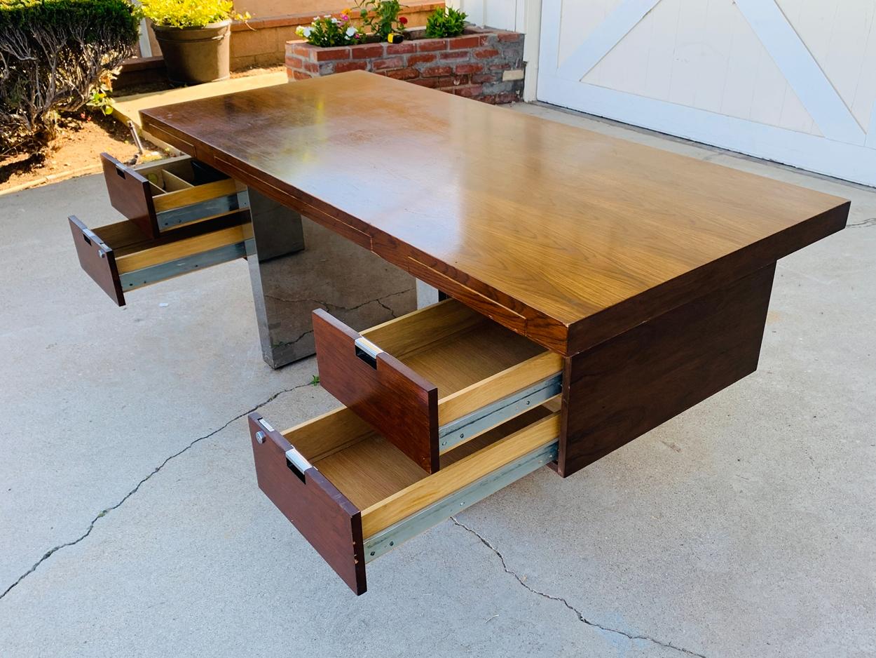 Large-scale Mid-Century Modern executive desk designed by Roger Sprunger for Dunbar. 

Gorgeous rosewood with stainless steel double pedestal base. Four drawers including one file, two regular and central slender pencil drawer. one pullout tray is