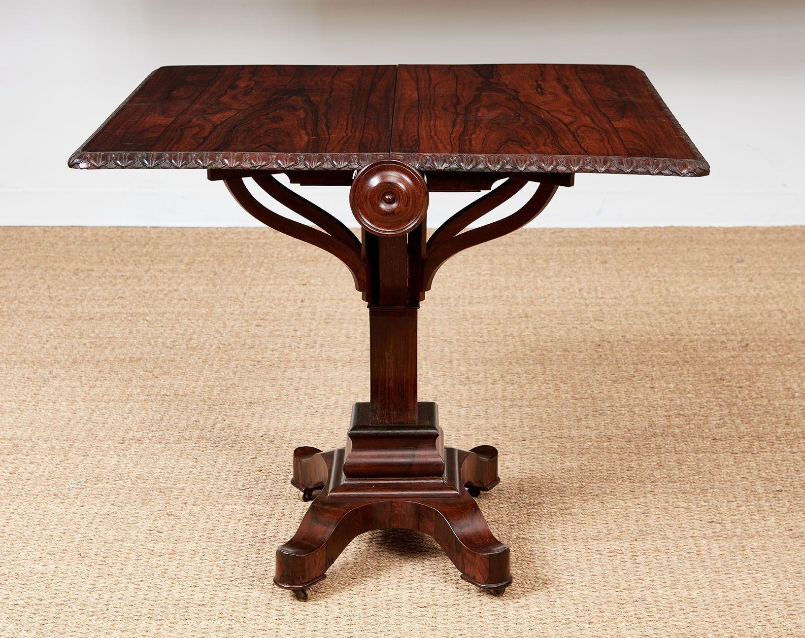 Une belle table du milieu du 19e siècle de Sunderland en superbe bois de rose, avec un plateau pliant à bord godronné sculpté sur une base élaborée composée d'un piédestal de section carrée avec quatre bras volants courbés sur une base à gradins en