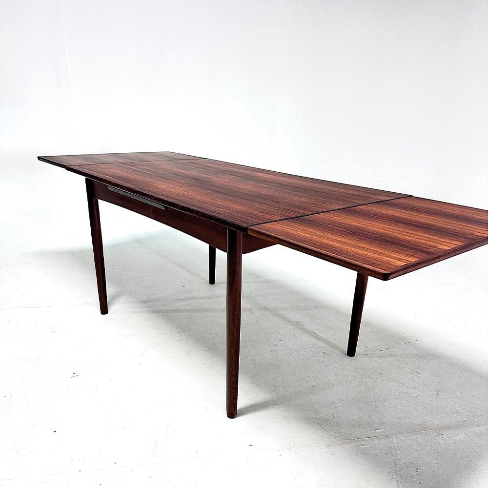 Die klaren Linien und minimalistischen Details dieses Tisches machen ihn zu einer eleganten und zeitlosen Wahl. Palisander bringt natürliche Wärme und hat die Fähigkeit, den Raum mit Tiefe und Einfachheit zu gestalten. Beachten Sie die schöne