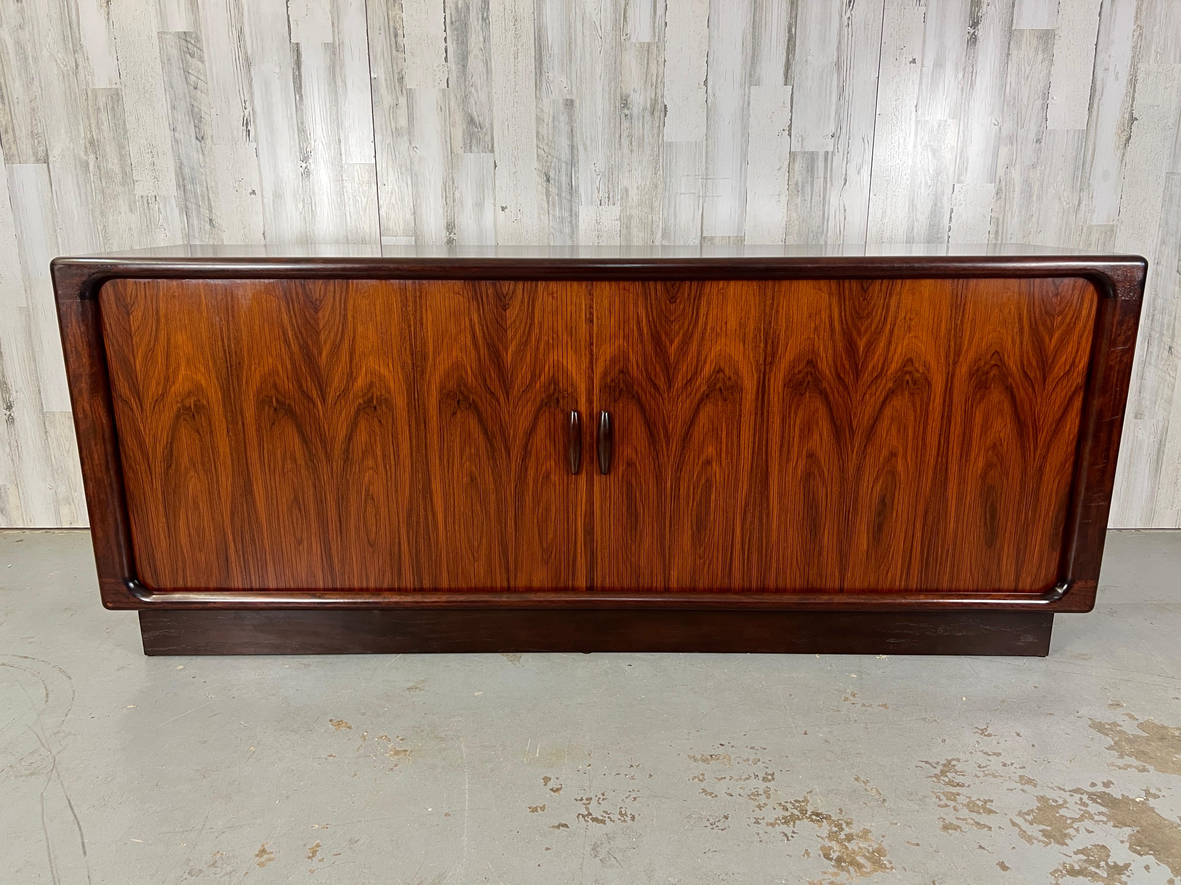 Rare Danish modern rosewood tambour door credenza with center dovetailed drawer section and adjustable shelf on each side.