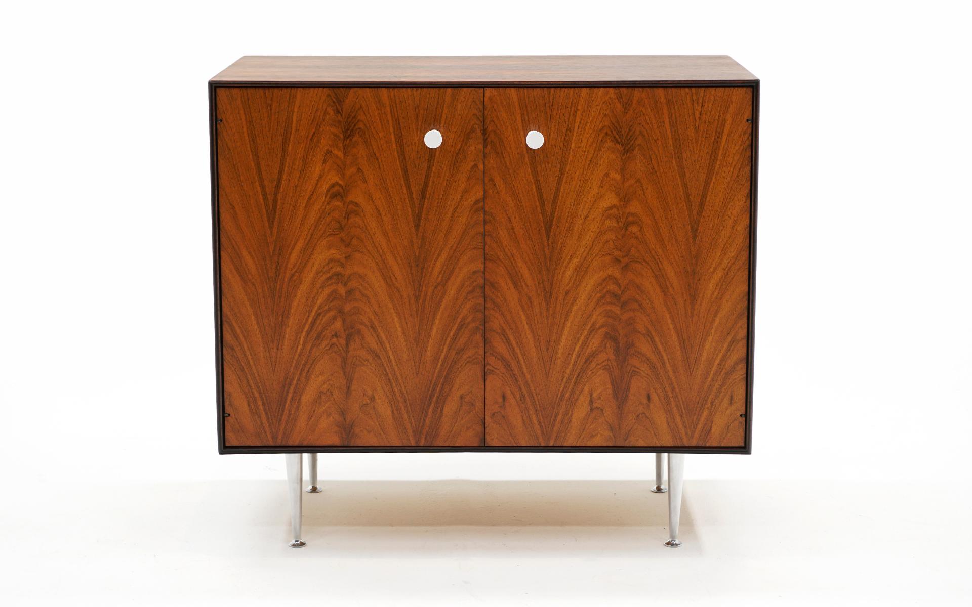 Stunning George Nelson for Herman Miller Brazilian Rosewood Thin Edge cabinet. Two doors with the original adjustable shelf. Porcelain pulls and cast aluminum legs. The figuring in the rosewood on this example is beautiful. Expertly refinished.