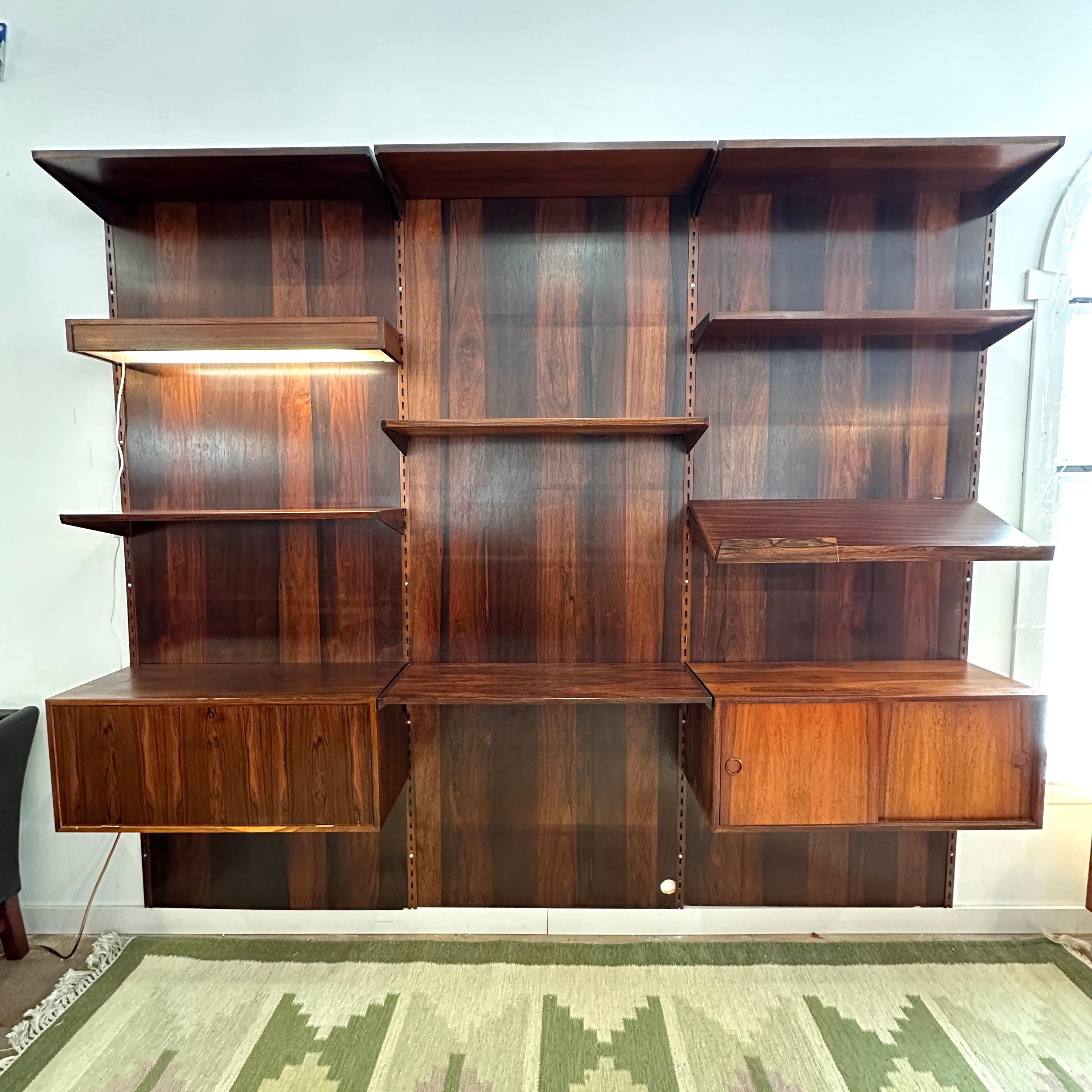 Condition: Great Vintage Condition

Dimensions: 103” L x 88” H x 12.5” D (Deepest)

Description: A vintage rosewood wall unit by Kai Kristiansen for FM Møbler. Gorgeous rosewood back panels - available with or without. A few holes in back panels cut