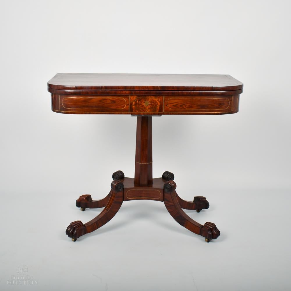 An extremely fine well figured Rosewood Regency (typical William IV) Tea table circa. 1840 with brass stringing decoration to the top and to the pedestal as well as the four splayed legs down to the prominent claw feet. The table top opens out to a