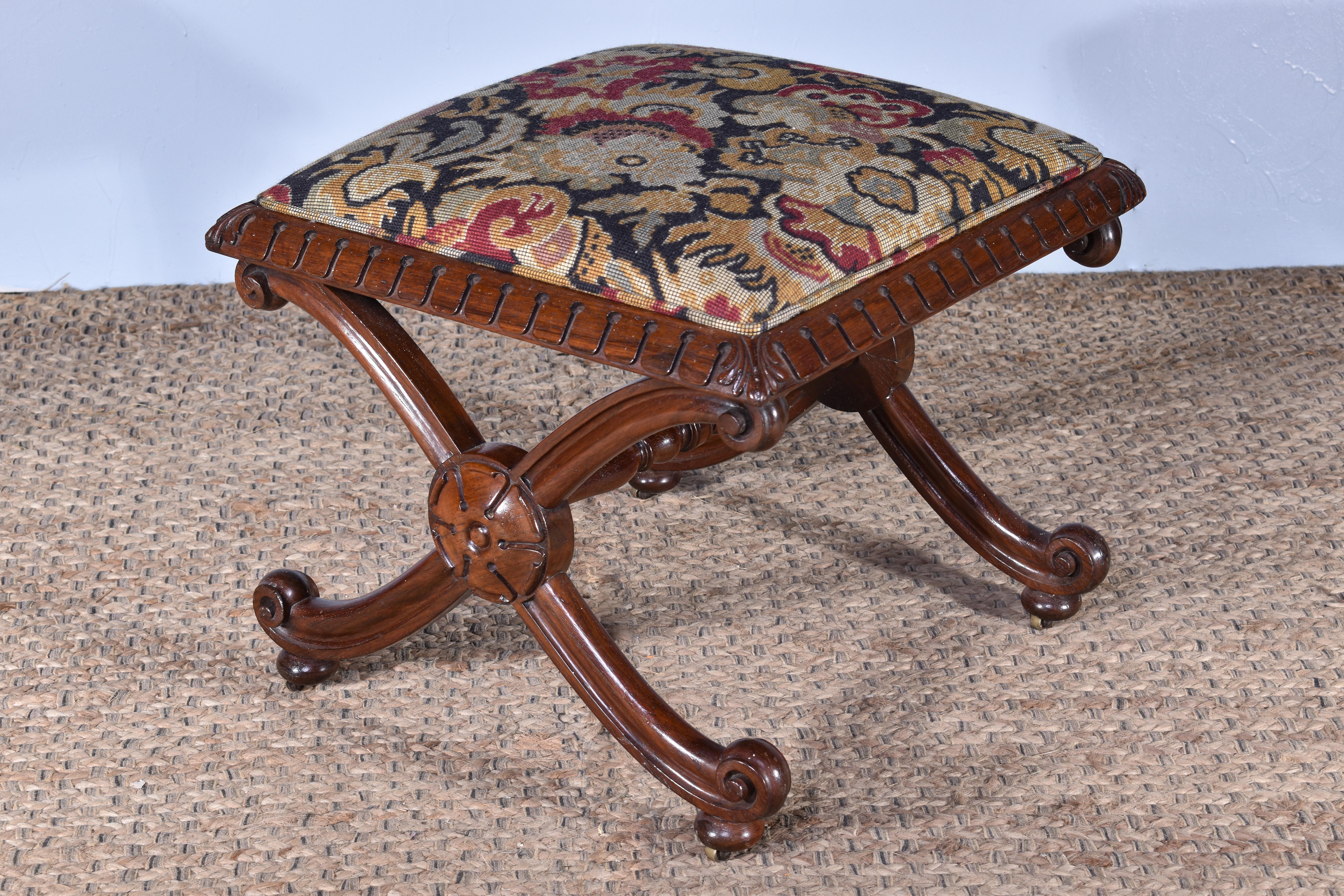 A George IV rosewood x-frame stool, C.1830.

Having x-frame supports and a crisply carved lappet frame, adjoined by a turned stretcher rail.

Raised on recessed original brass castors, traditionally upholstered in a needlepoint fabric.

Structurally