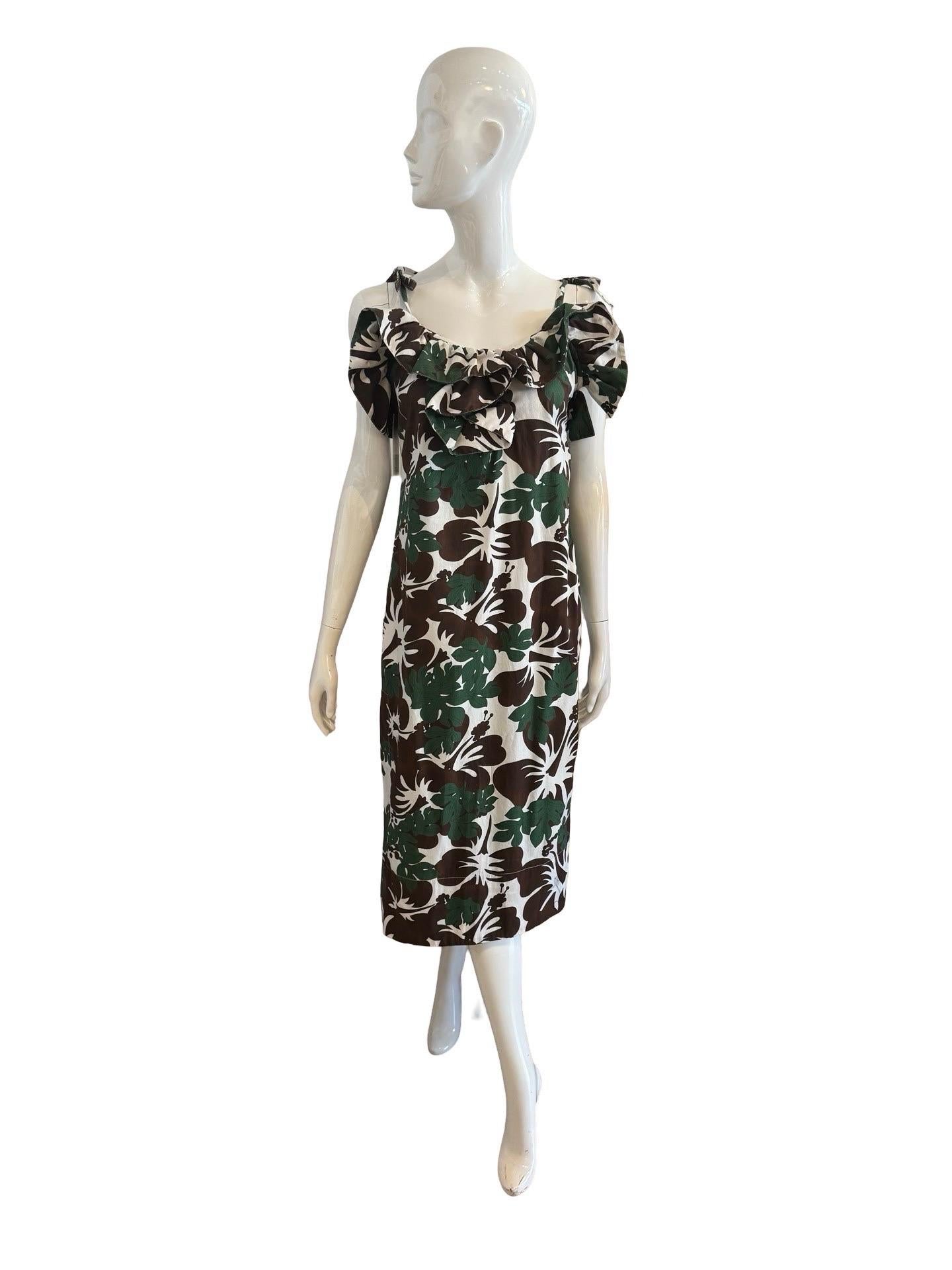 El Resortware perfecto de la reina de la diversión, Rosie Assoulin.  Vestido de algodón con estampado tropical de hojas marrones y verdes y flores de hibisco.   Tiene un escote sudadero con volantes que también tiene una abertura en forma de ojo de