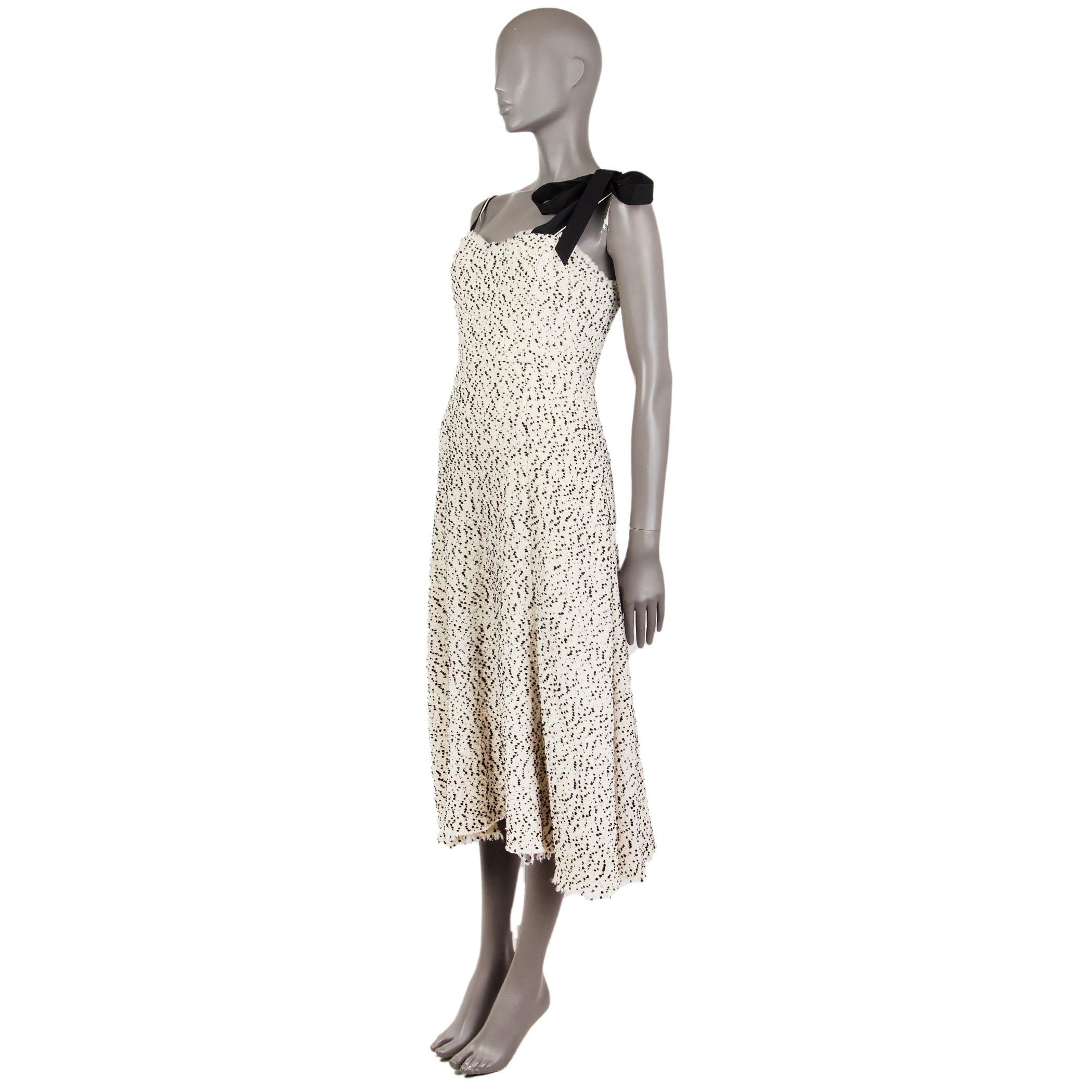 100% authentic Rosie Assoulin dalmatian-tweed dress in off-white and black wool (81%), patac (8%), nylon (5%), polyester (5%), and lycra (1%). With frey trims, one spaghetti strap, ribbon straps on the other shoulder, sweetheart neckline, and flared