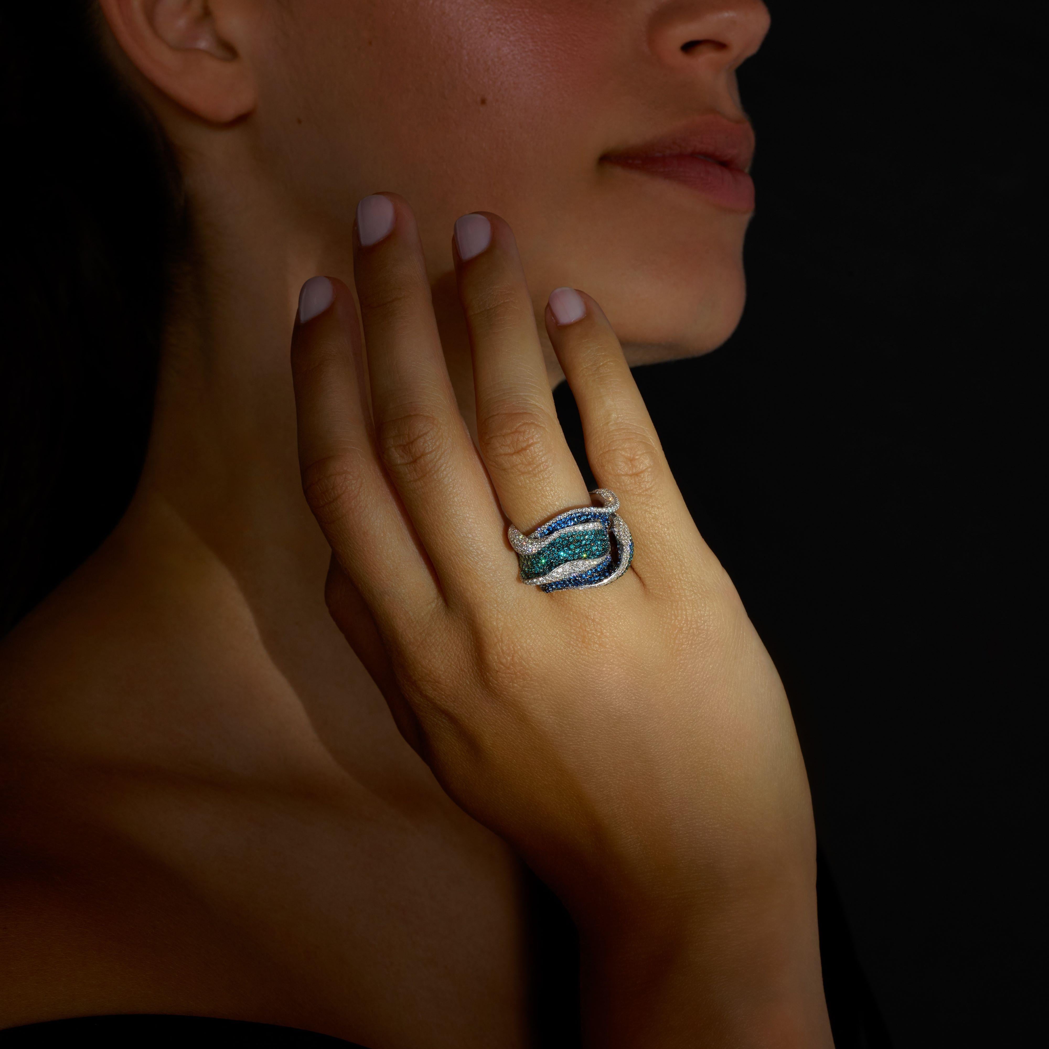 A one-off creation ring, inspired by the ocean, by Rosior Portugal made in white gold and set with:
- 344 IGI certified natural diamonds, F color, VVS clarity, weighing 2,19 ct;
- 243 blue diamonds weighing 1,81 ct;
- 180 blue sapphires weighing