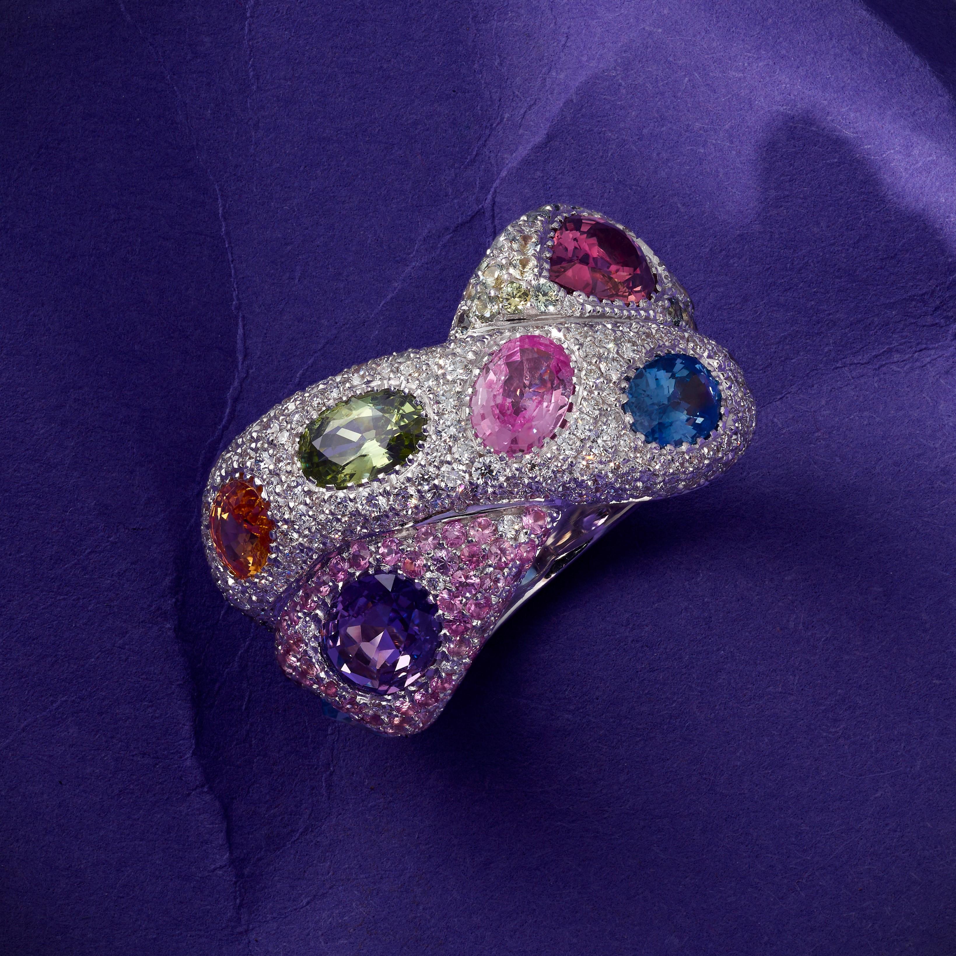 A White Gold cocktail Ring by Rosior Portugal, set with:
- 244 Natural Colorless Diamonds weighing 1,47 ct;
- 48 Green Sapphires weighing 0,60 ct;
- 80 Pink Sapphires weighing 0,66 ct;
- 2 Oval Cut Purple Sapphires weighing 1,45 ct;
- 1 Oval Cut