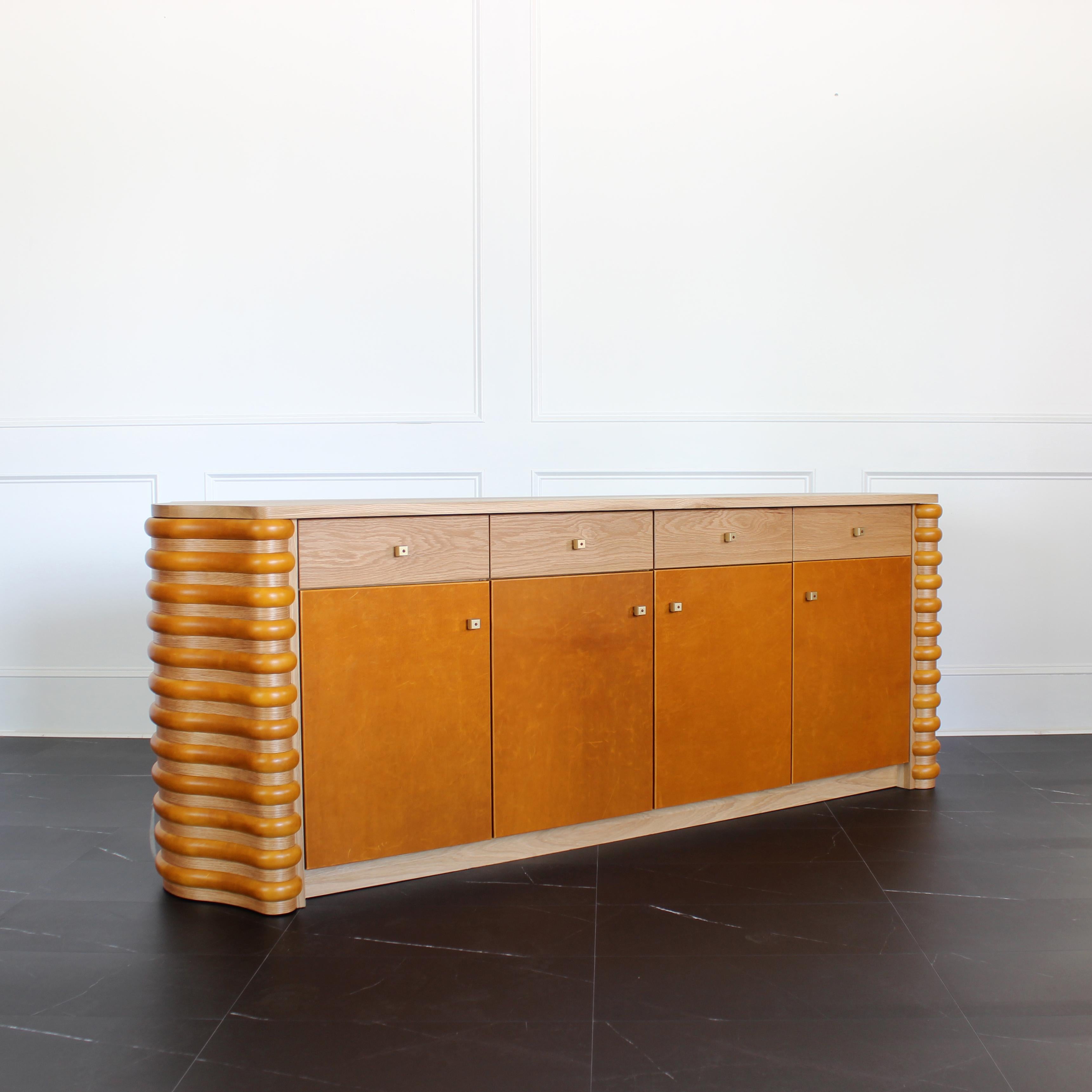 The Roslin Credenza by Crump and Kwash 

Features both solid wood and laminate construction / low VOC acrylic finish / sustainably sourced leather wrapped doors / premium, full extension, soft close drawer slides / solid maple, dovetailed drawer