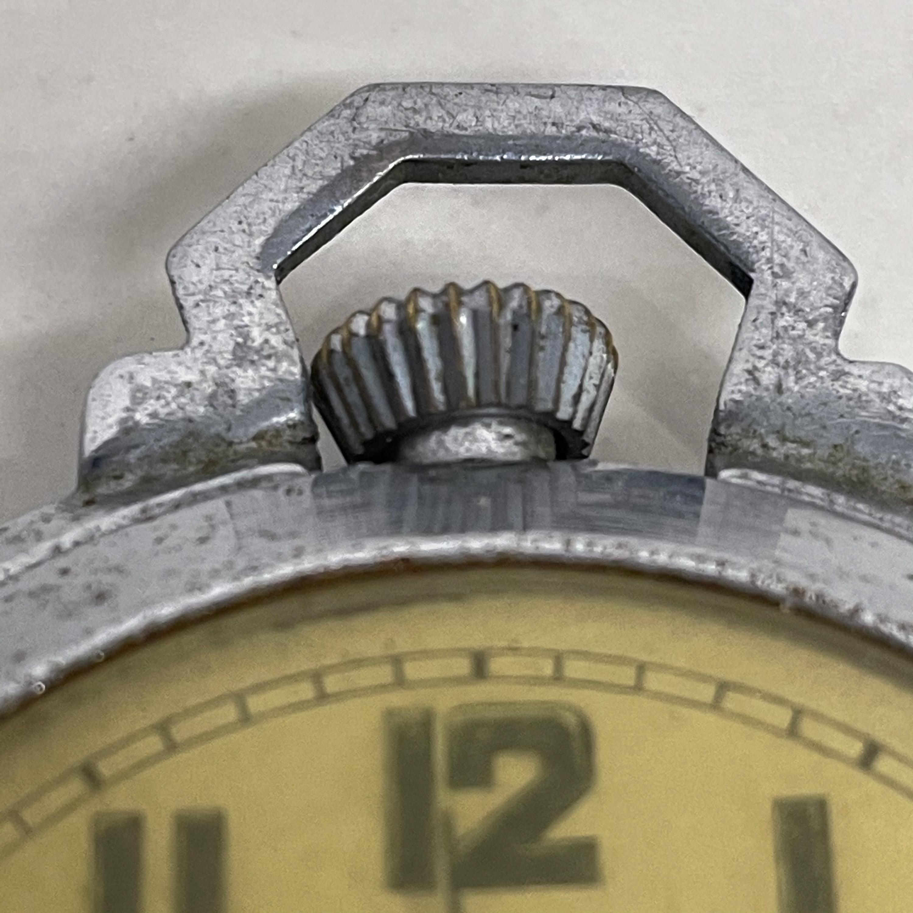 ROSPIN vintage stylish pocket watch.
Size: 2.38 T x 2.13 W x .5 D
Stamped: ROSPIN 7 Jewels Swiss Made 
Chrome plated metal with plastic. Outer rim folds into a stand.
Original unrestored vintage condition. Features a folding plate that is not