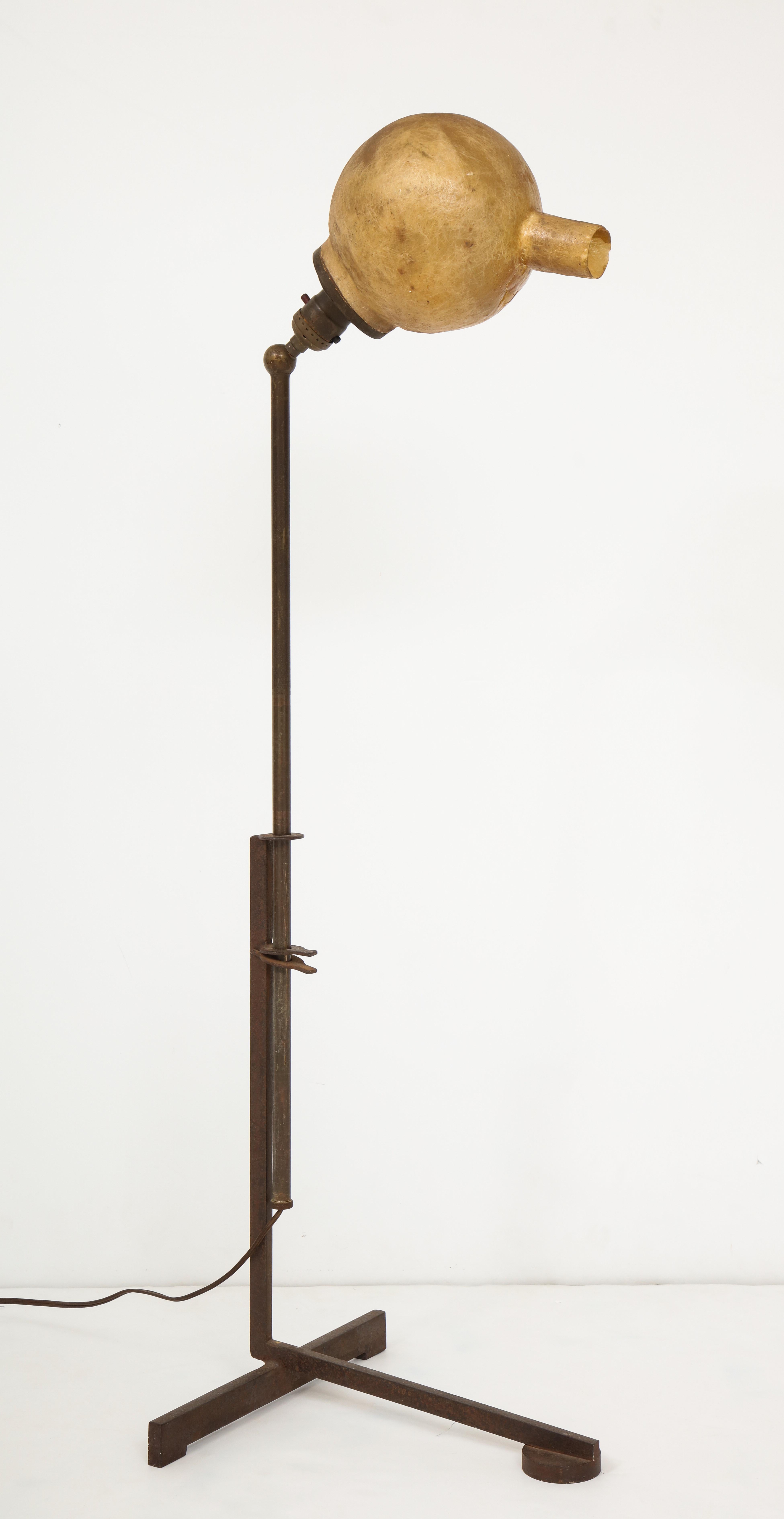 Adjustable (up-and-down and pivoting) floor lamp with a Constructivist iron base surmounted by a quirky, almost anthropomorphic hand-molded fiberglass diffuser–an early use of fiberglass in product design. A one-off by Ross Bellah, made in the