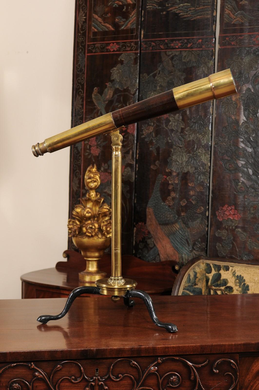The telescope on Stand with leather/brass barrel and black painted tripod feet, signed 