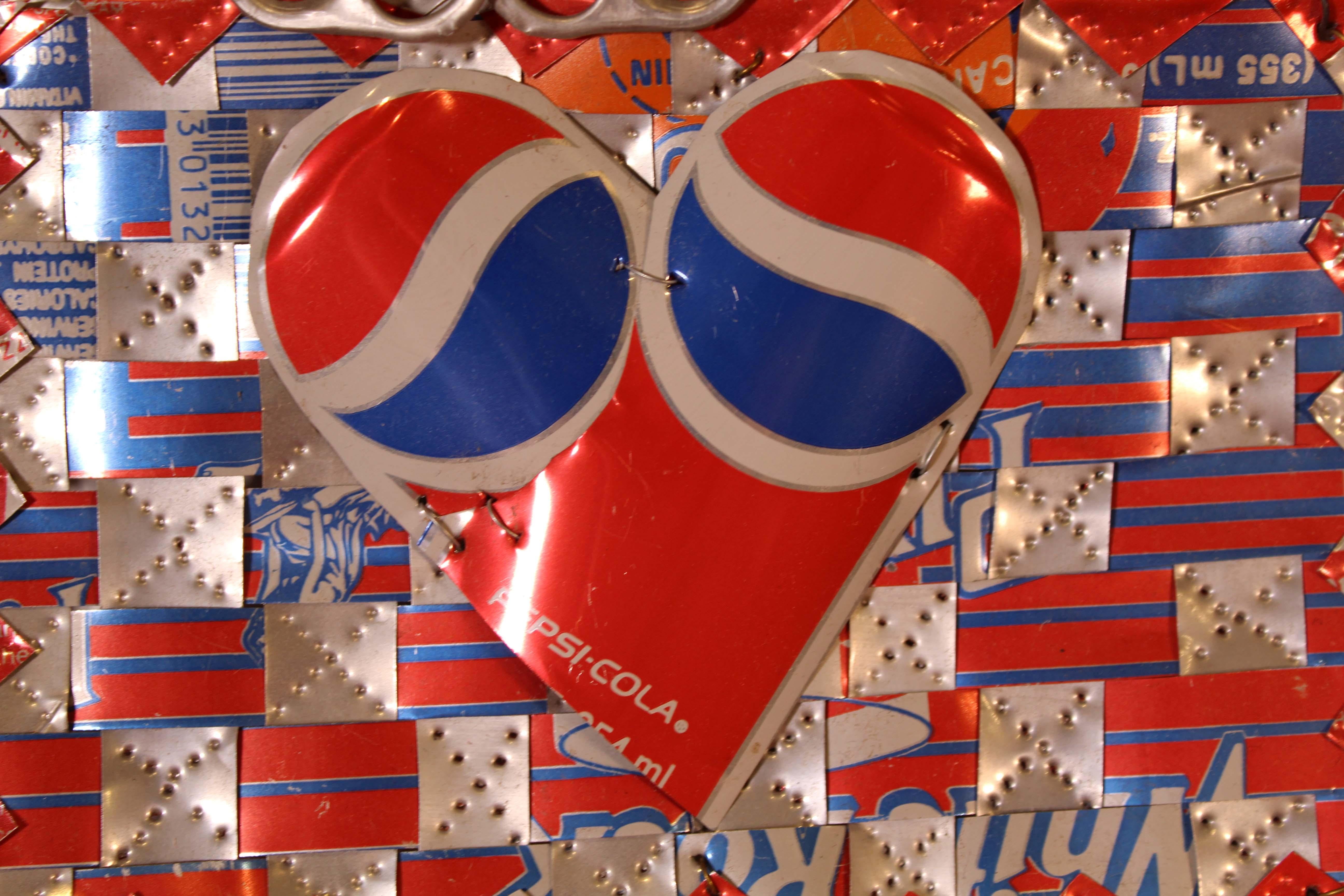 Un assemblage unique d'objets trouvés contemporains fait de canettes de Pepsi et de Hawaiian Punch par l'artiste américain Ross Palmer Beecher. Signé à la main au sharpie au verso. L'artiste a tissé ensemble des éléments de boîtes de conserve pour