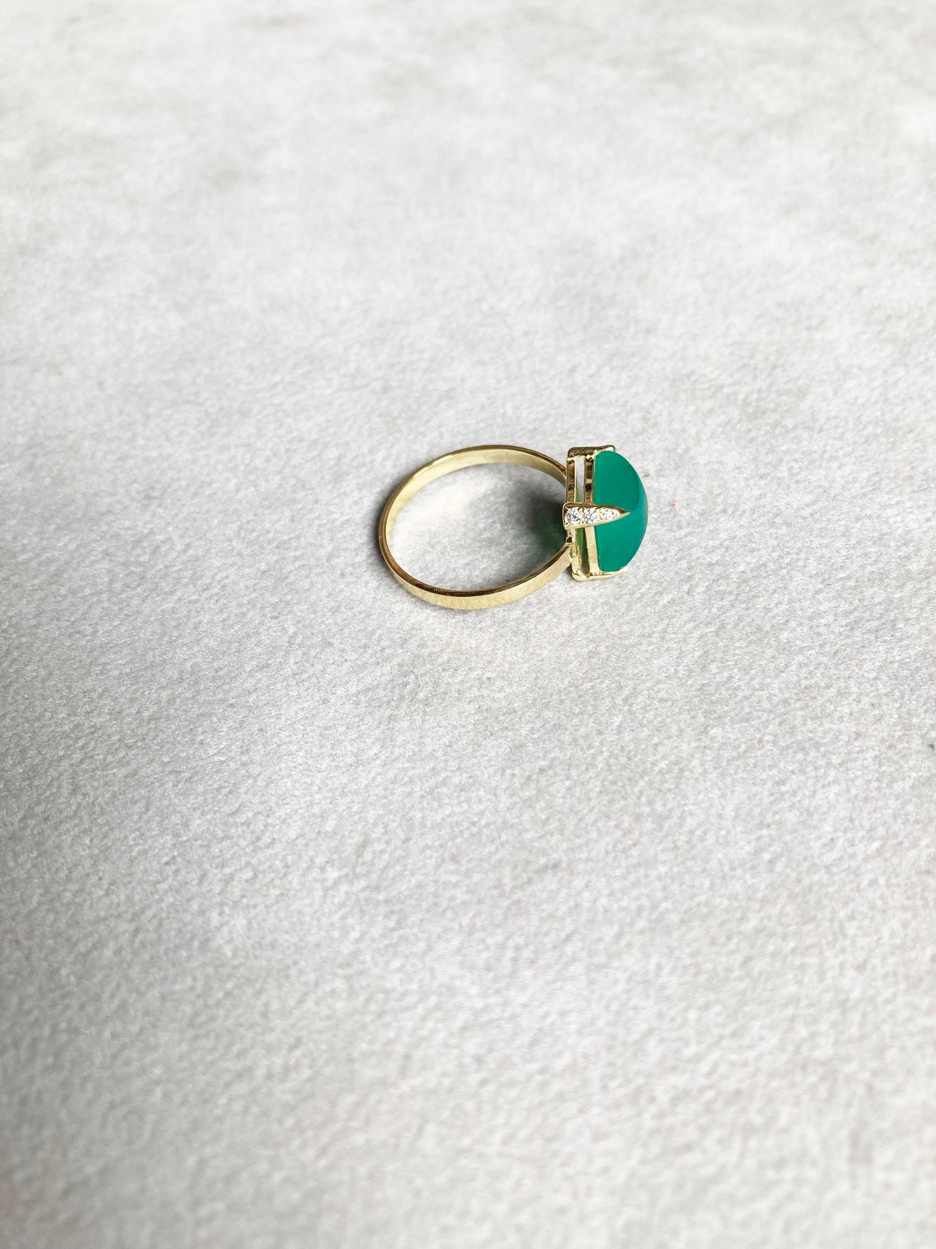 Embark on a timeless journey with Rossella Ugolini's 18K Yellow Gold Ring, featuring an enchanting emerald-green color pyramid of sugarloaf-cut Green Agate. The ring's shank, a flat 3 mm band of yellow gold, bears a subtle hammered texture,
