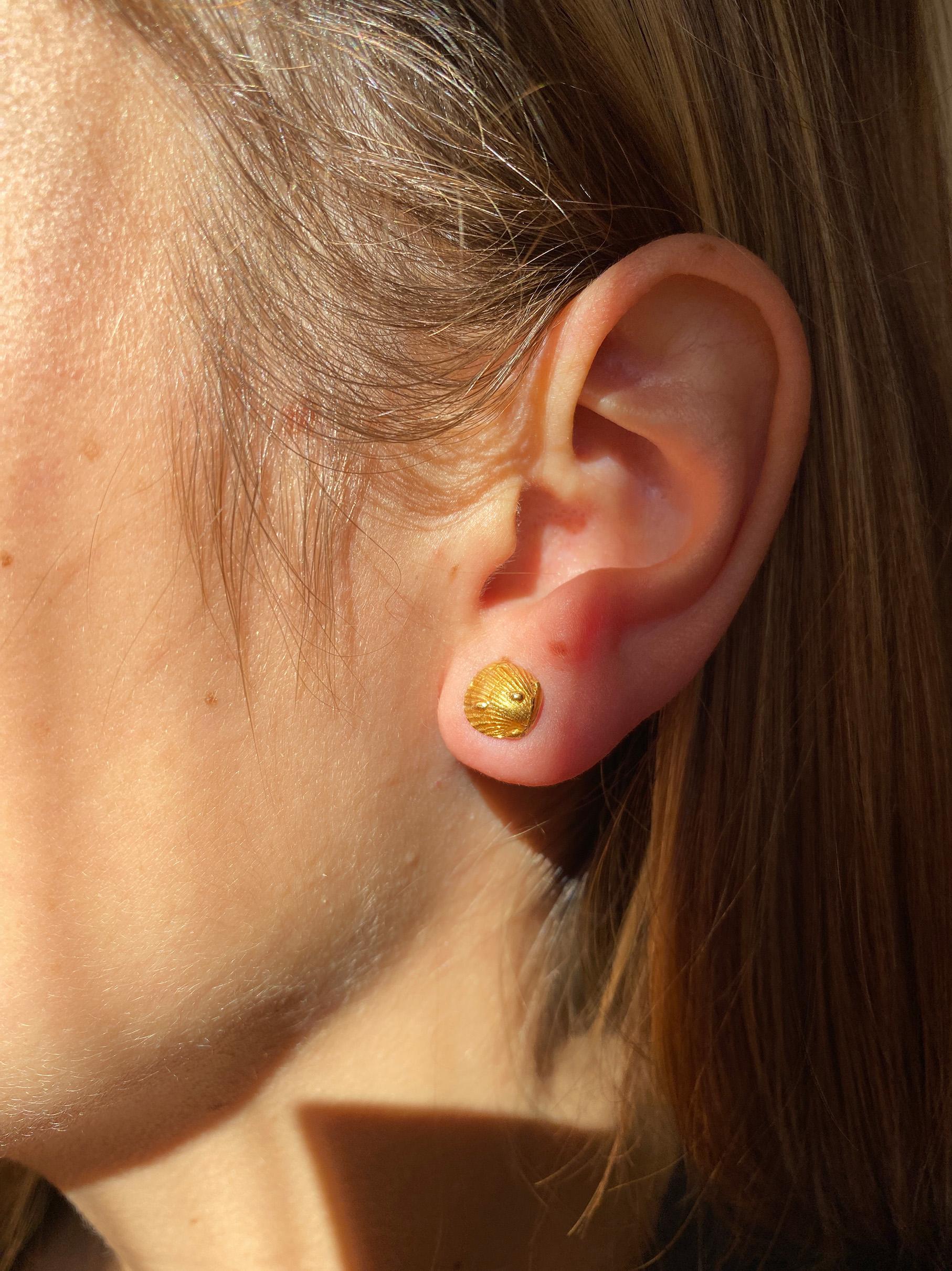 Orecchini Rossella Ugolini in oro giallo 18 carati. Questi squisiti orecchini unisex, che misurano 0,7 mm, sono un capolavoro made in Italy, che evoca le sabbie incontaminate e le acque cristalline della Sardegna e le incantevoli spiagge sparse in