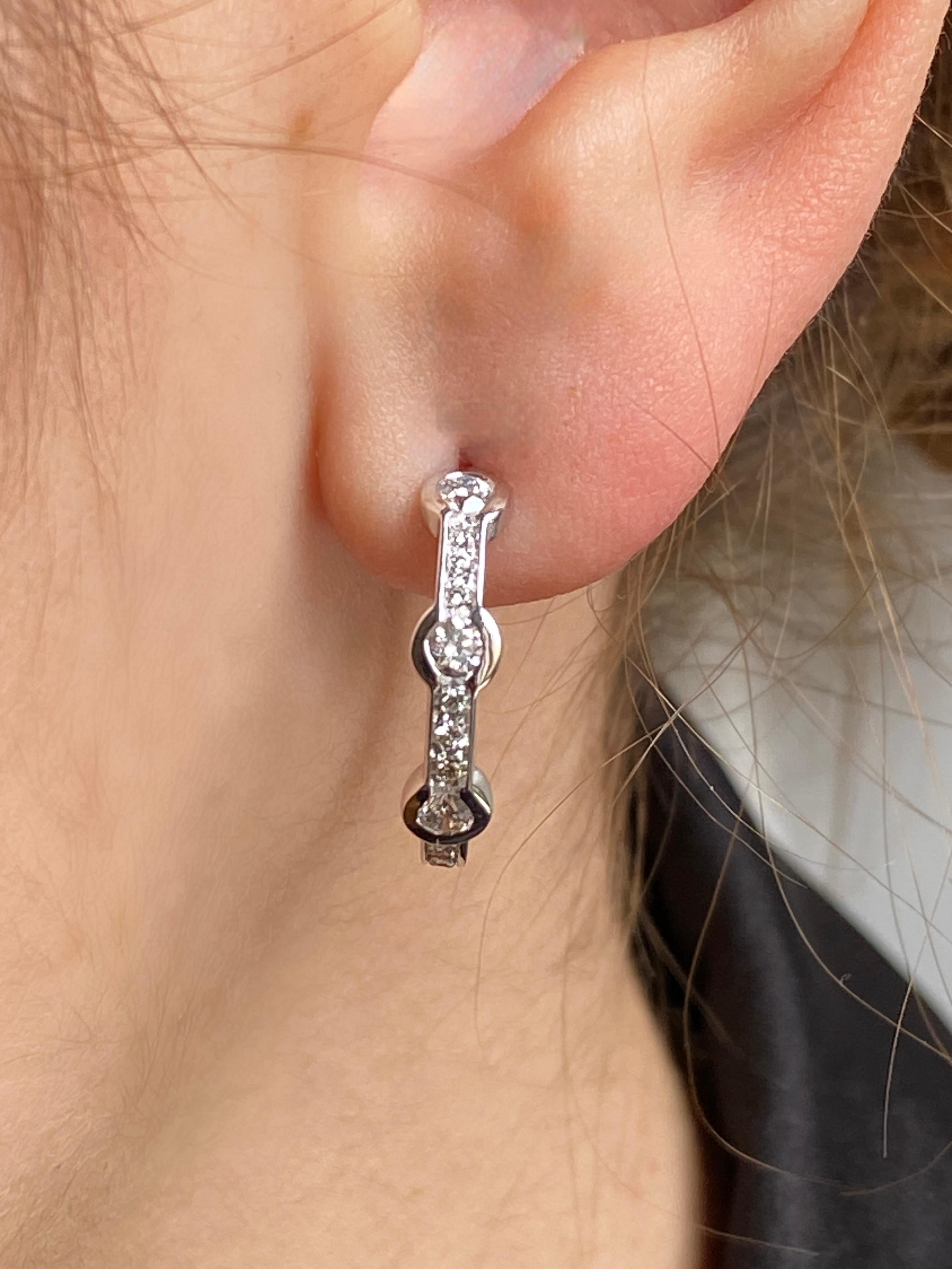 Rossella Ugolini hoop earrings, crafted in 18K white gold and adorned with 0.60 carats of stunning white diamonds. These earrings are handcrafted in Italy and measure 2 cm in diameter. Each earring features a design of three large Diamonds