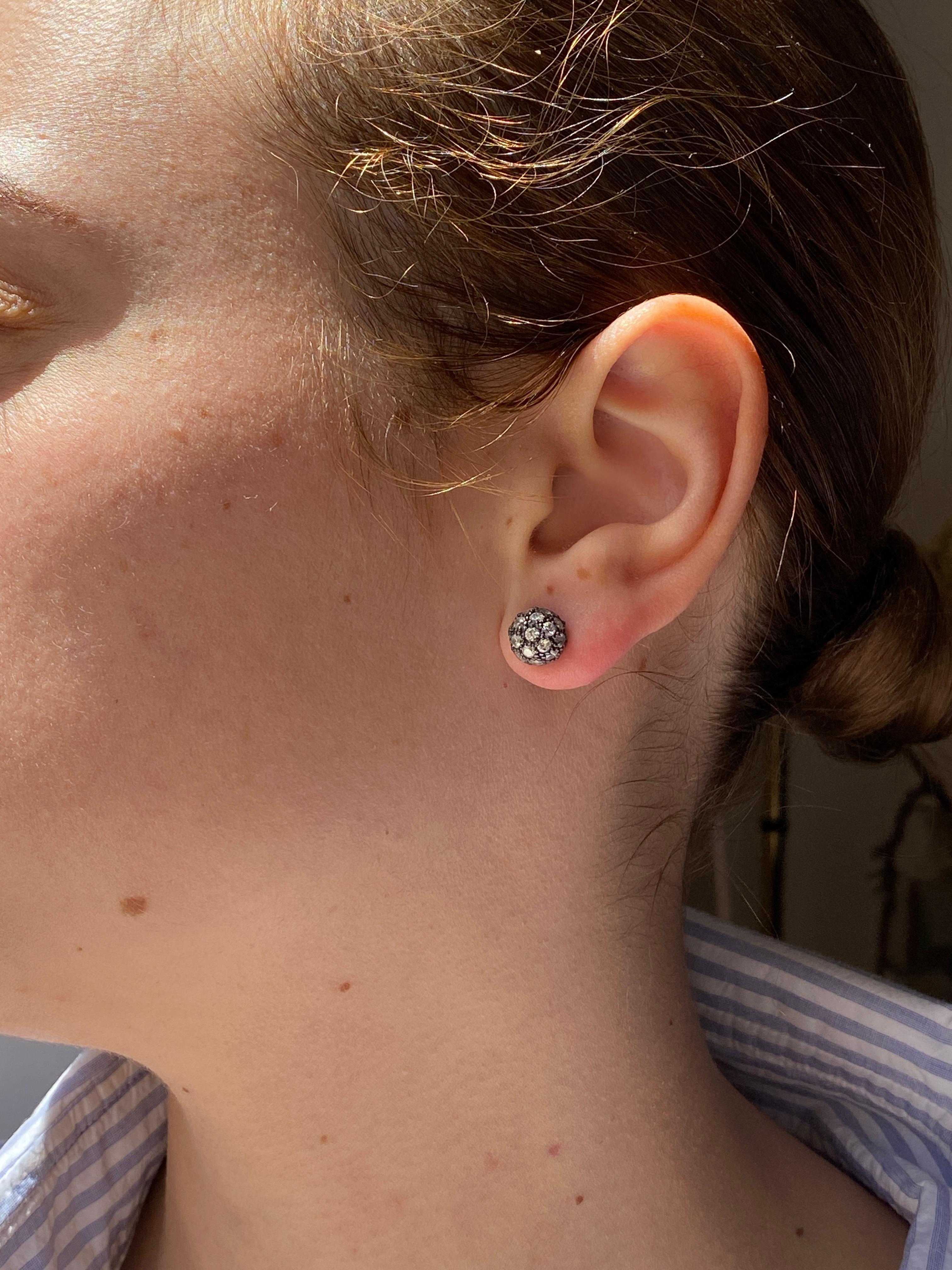 Ti presentiamo gli orecchini a perno Unisex di Rossella Ugolini, un sofisticato mix di eleganza e design contemporaneo, realizzati con precisione in oro bianco, rodio nero e diamanti grigi. Ogni orecchino presenta una sfera di 0,8 mm in oro brunito,