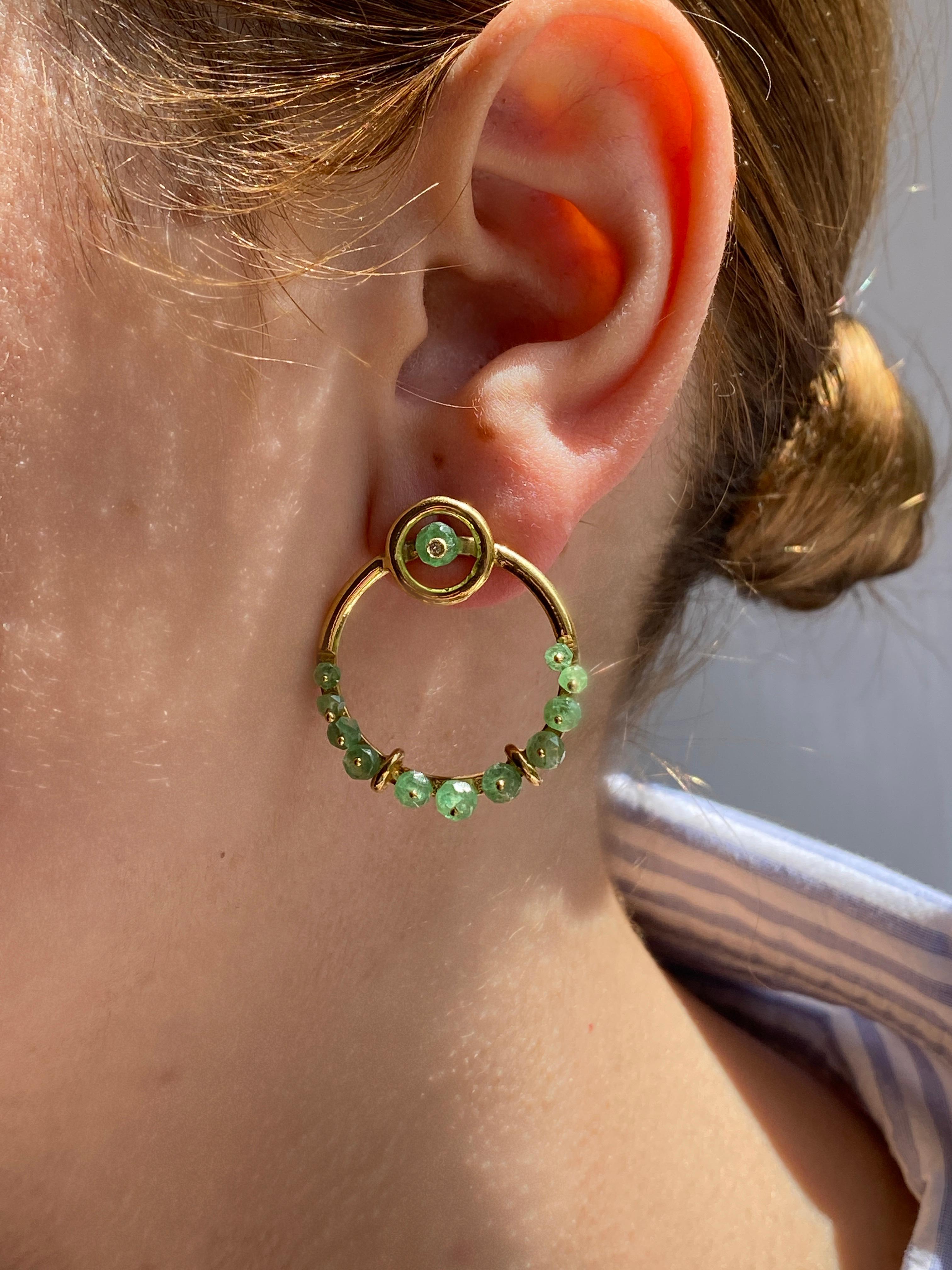 Ready to Ship, Rossella Ugolini Emerald and Diamonds Circle Hoops earrings Crafted in 18k yellow gold, these double hoop earrings feature two distinct circles. 
The first, a small circle gracefully placed on the lobe, boasts a captivating emerald