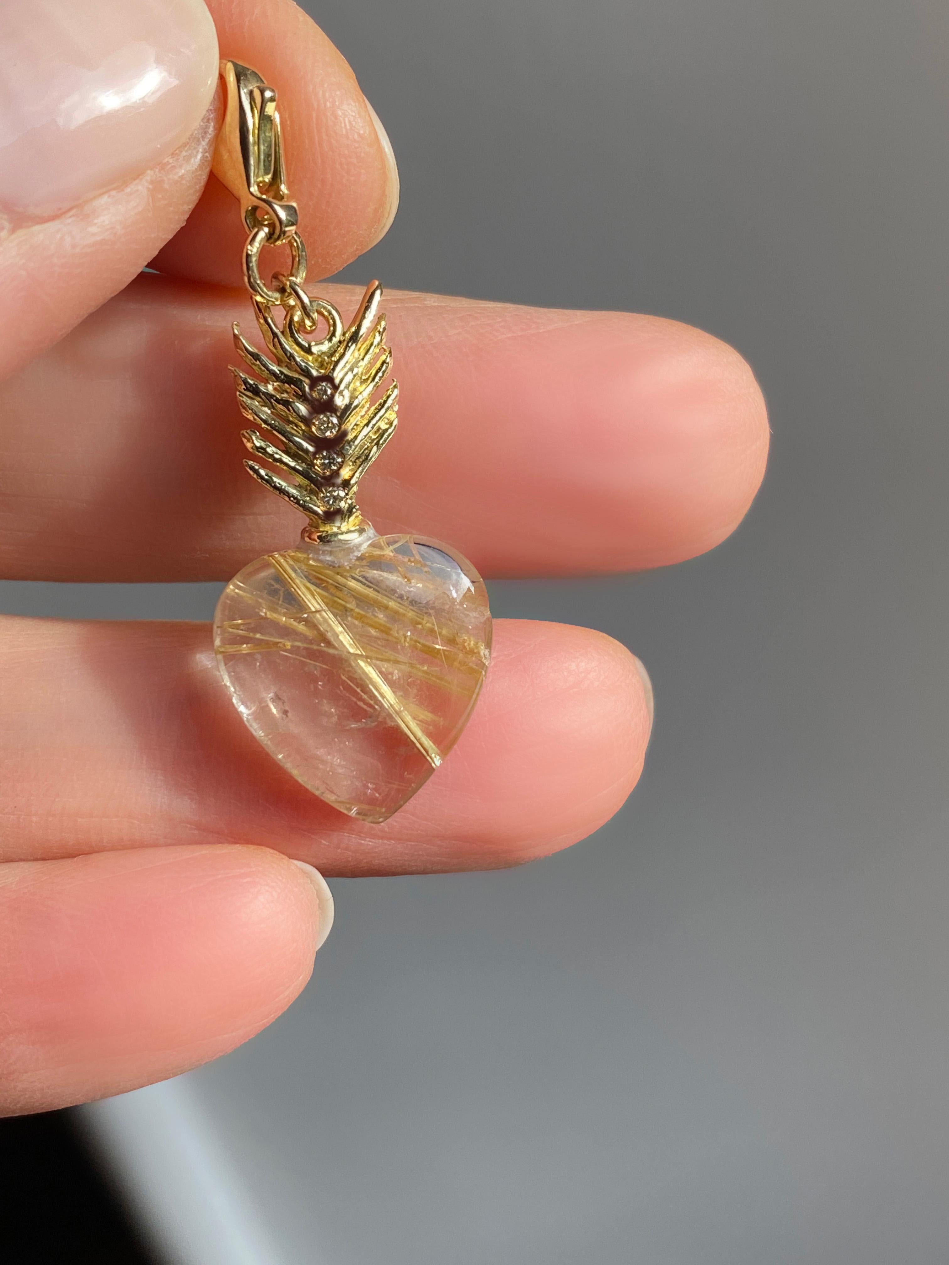 Rossella Ugolini, or jaune 18 carats  Charm de cœur en quartz rutile et diamants blancs.  Dimension : longueur in.0,98  x diamètre en 0,55 (2,5 x 1,4 cm ). Breloque en or jaune 18k réalisée en Italie, présentant un quartz rutilé en forme de cœur