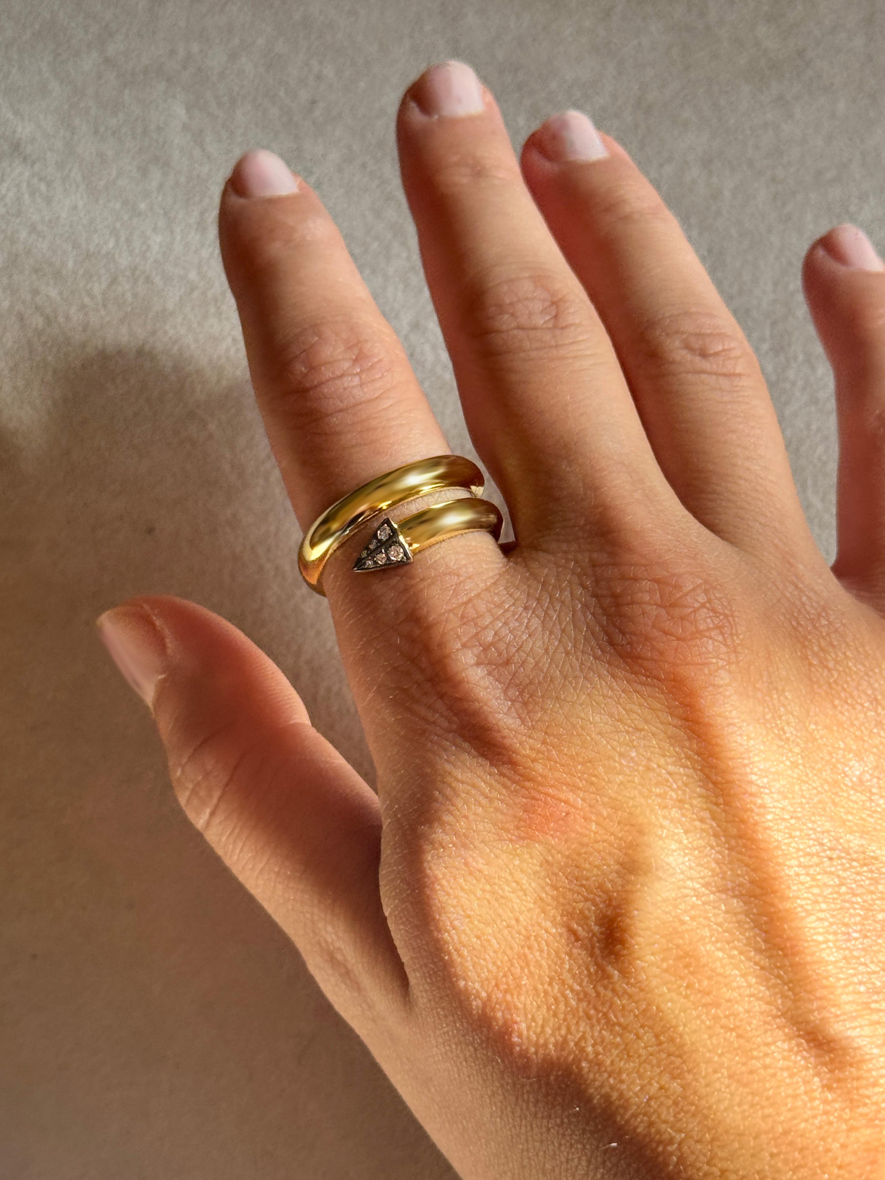 Anello da uomo Rossella Ugolini in oro giallo 18 carati con diamanti bianchi, misura 10, finitura lucida. La fascia in oro giallo 18k da 5 mm si snoda intorno al dito e termina con una punta di freccia. La freccia è incastonata con diamanti bianchi,