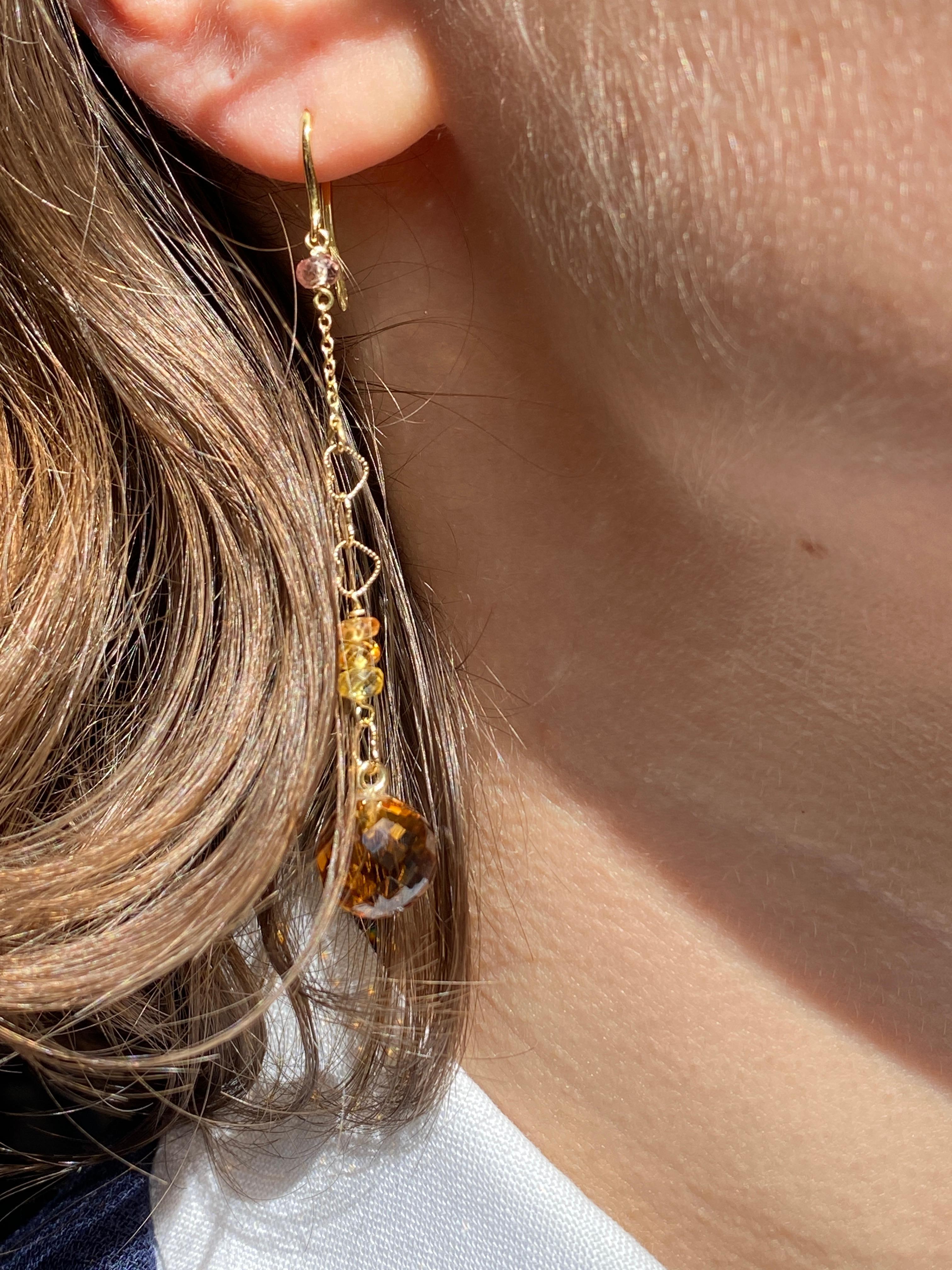 Rossella Ugolini design 18k Yellow Gold Yellow Sapphires and Round Citrine Dangle Hearts Chain Earrings. These 18k gold earrings feature an elegant 18k yellow gold hook that rests delicately on the earlobe, suspending a light yellow sapphire bead.
A