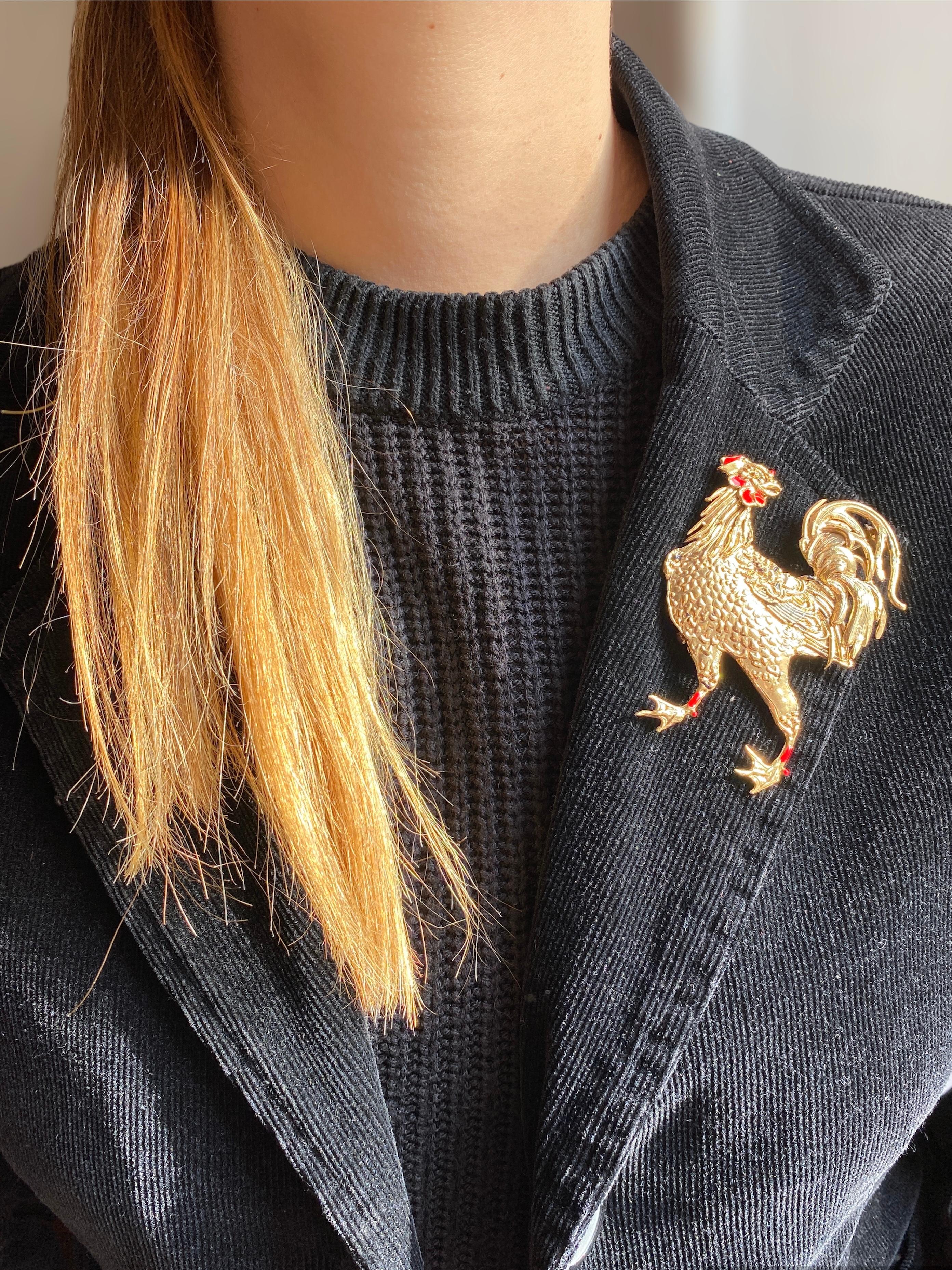 Rossella Ugolini design collection handcrafted masterpiece from Italy: a playful and dynamic Rooster brooch, meticulously crafted in bronze and plated in luxurious 24k gold. This charming creation features enameled wattles in vibrant red, with
