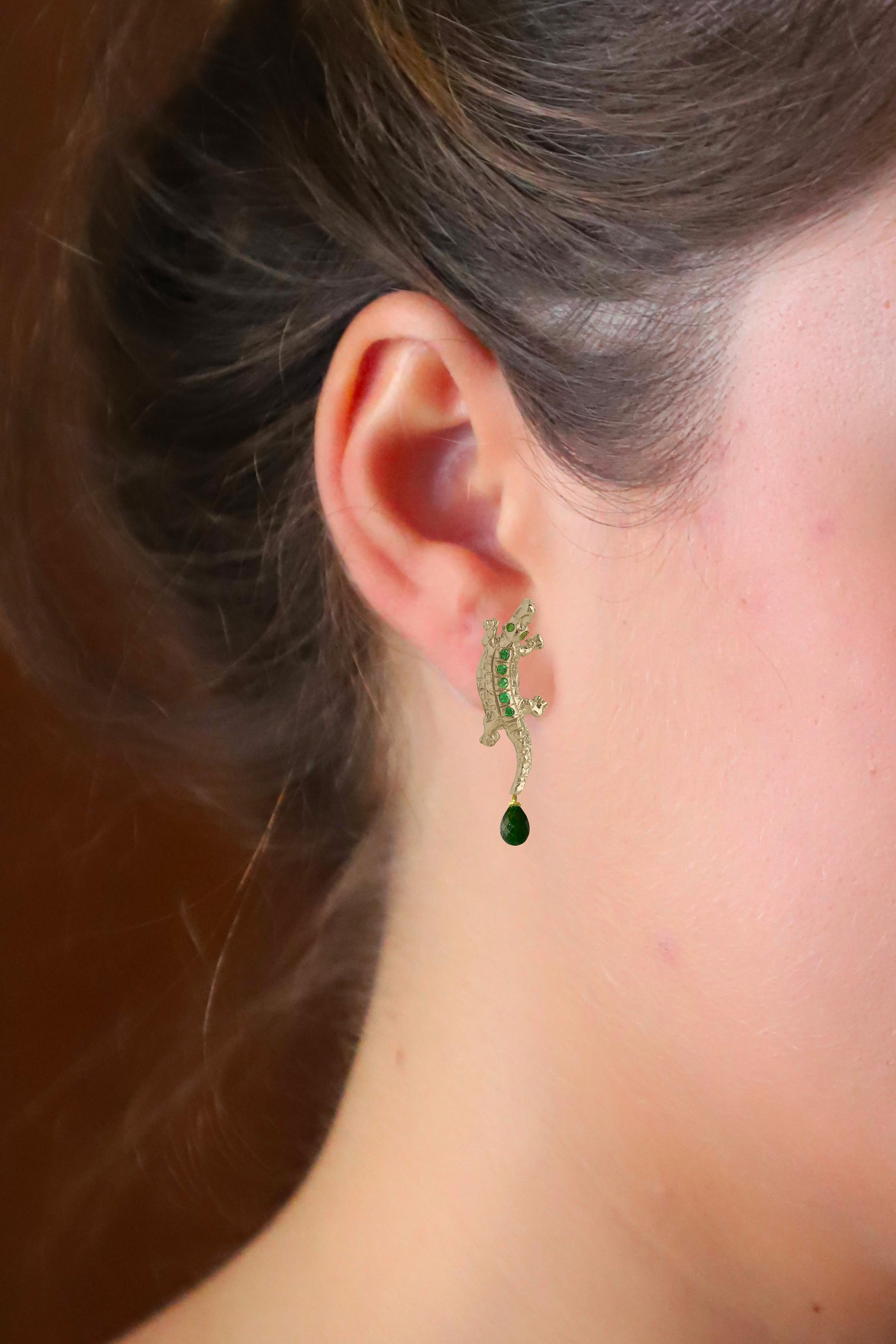 Explore the allure of Rossella Ugolini's 18K yellow gold alligator earrings, a captivating blend of ancient symbolism and contemporary elegance. Adorned with vivid round green Emeralds, the eyes and body of each crocodile come alive with color.