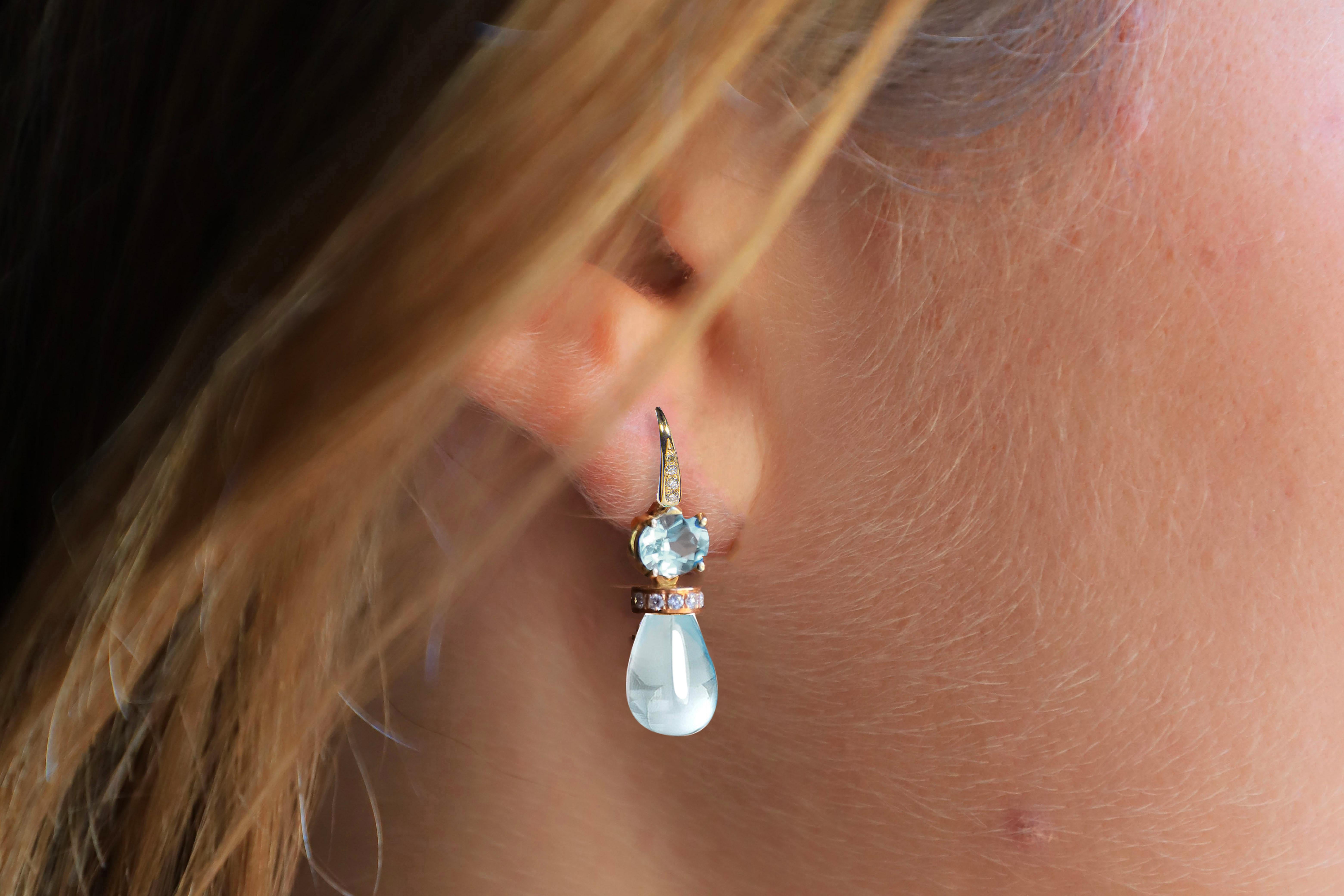 Introducing Rossella Ugolini's 18K Yellow Gold Earrings a masterful blend of timeless elegance and captivating gemstones. The focal point of these exquisite earrings is the mesmerizing Aquamarine duo, featuring an oval-cut and a pear-cut gem, each