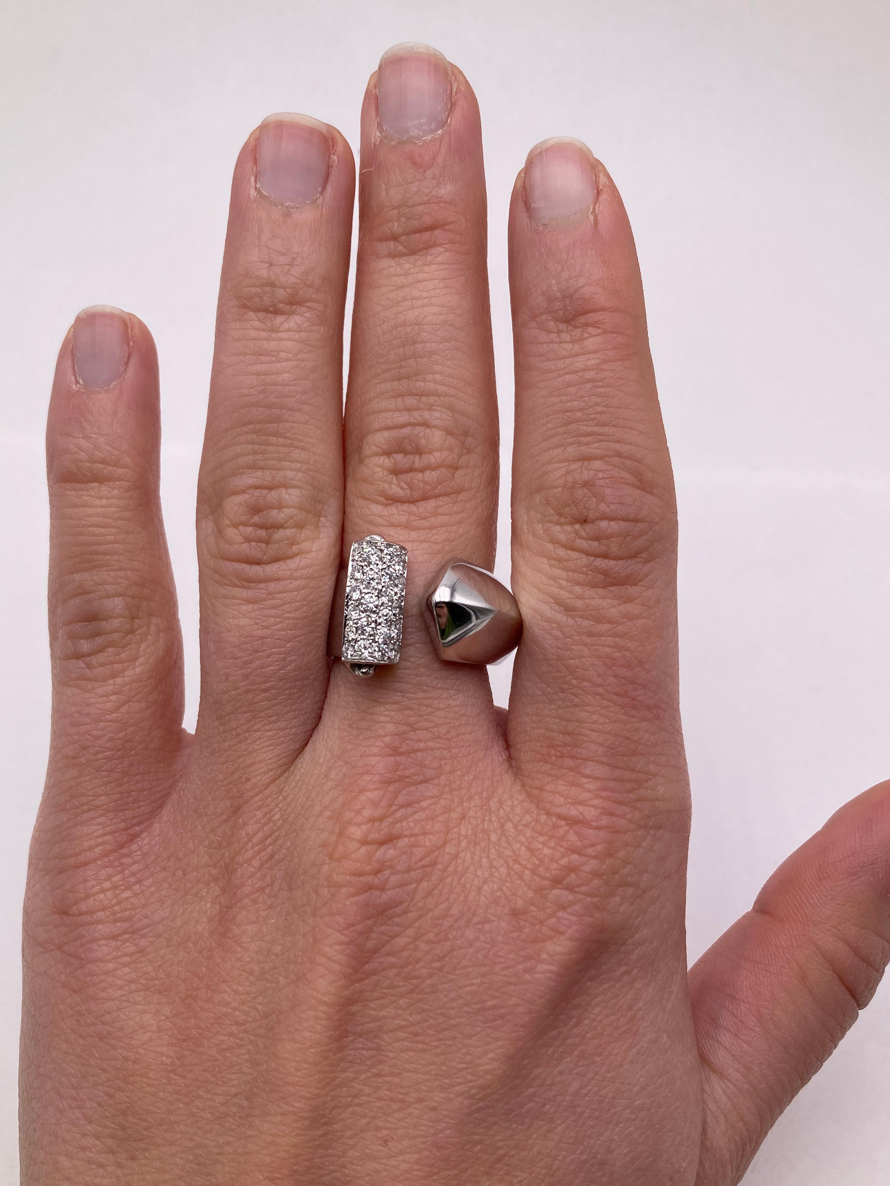 Embrace Timeless Sophistication with Rossella Ugolini's 18 Karat White Gold Deco Style Ring. This stunning piece pays homage to the Deco era, elegantly wrapping around your finger with a gentle embrace and extending outward with a captivating