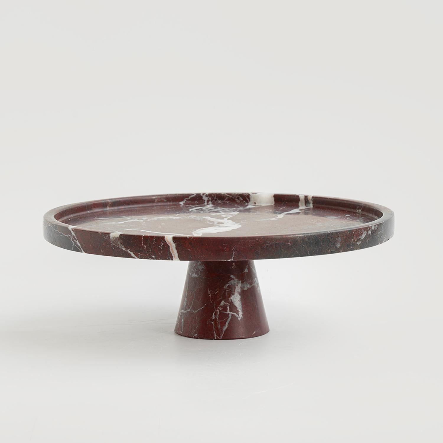 Rendi straordinaria ogni occasione con l'alzata per torte in marmo Rosso Levanto, un centrotavola straordinario che unisce eleganza e funzionalità. Realizzato in lussuoso marmo bordeaux con esclusive venature bianche, il suo design senza tempo