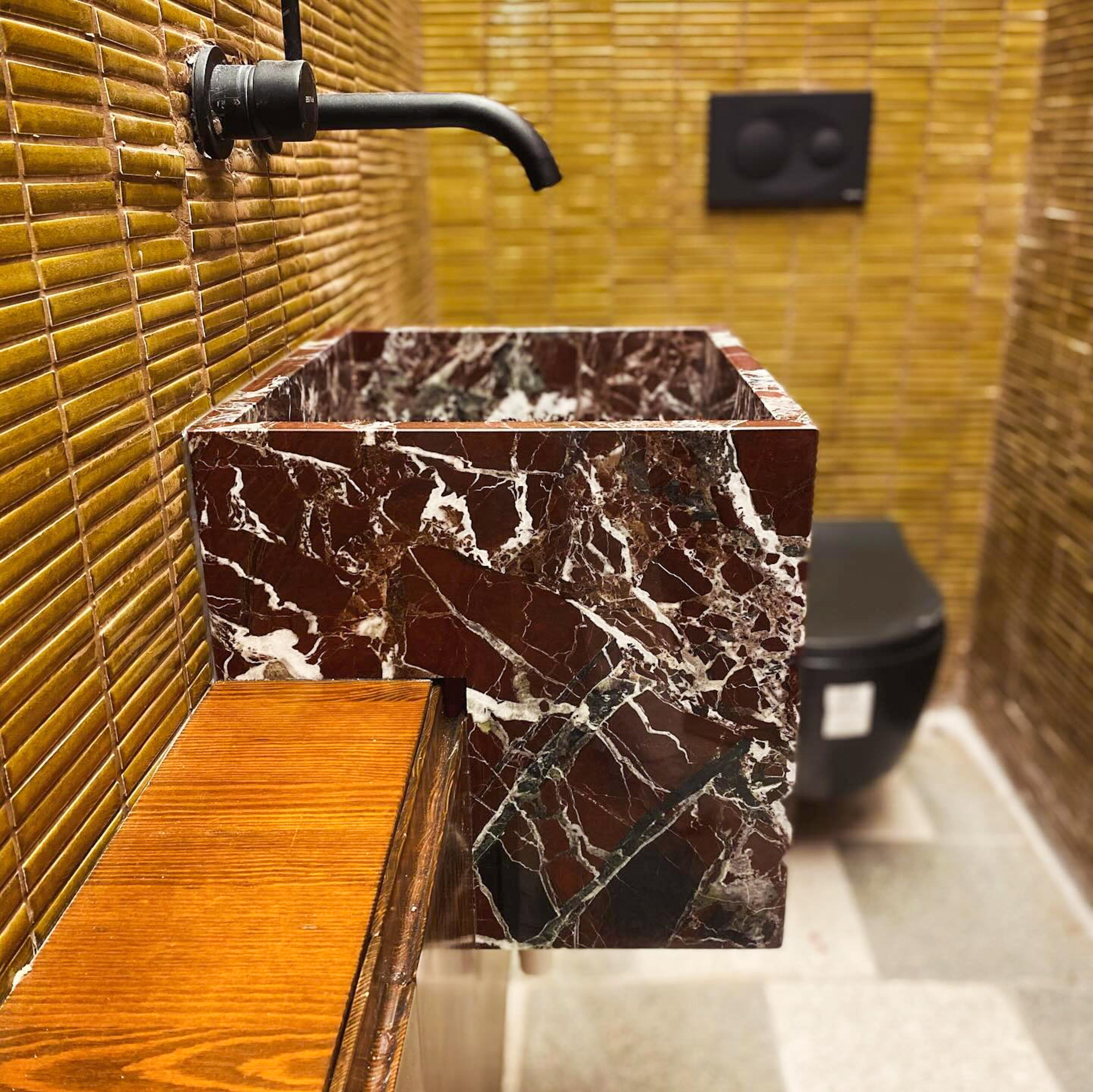 Questo lavabo in marmo Rosso Levanto, unico nel suo genere, conferisce un aspetto audace e raffinato a qualsiasi bagno o stanza della polvere. Realizzato a mano con vero marmo turco, presenta ricche tonalità bordeaux evidenziate da venature bianche
