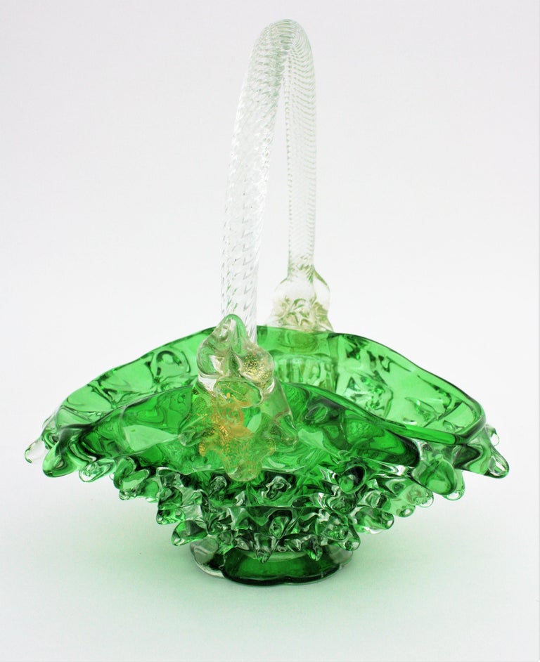 Ercole Barovier Murano Rostrato green and clear gold flecked glass basket vase
Exquisite green Rostrato Murano art glass basket vase with a twisted clear glass handle and feminin faces with gold leaf aventurine flecks decorating each side.
Ercole