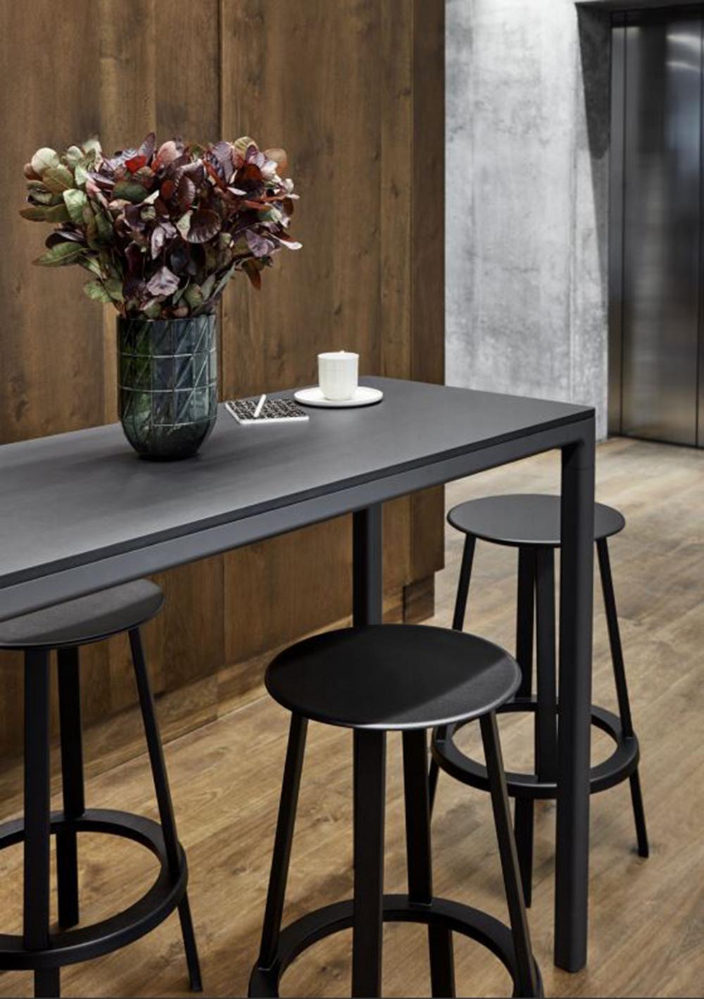 The Revolver bar stool is positioned on a bearing mechanism that enables the seat and footing to rotate 360 degrees. 
The slim, slightly dished seat features curved edges for additional comfort, while the footrest provides support and the weighty