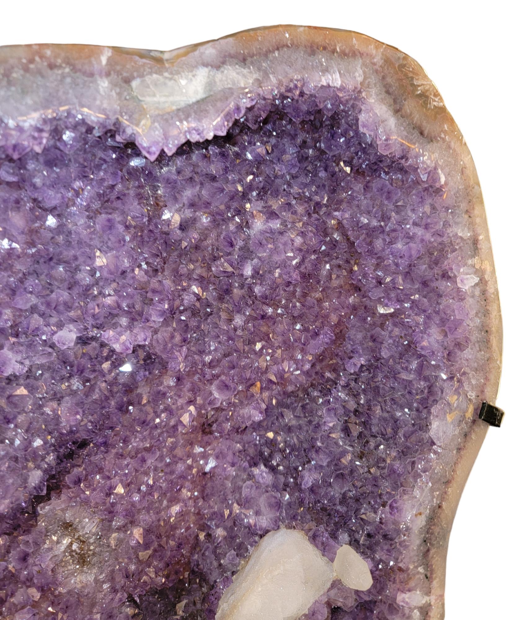 Rotierende Achatgeode mit Amethystkristallen. Der Sockel dieses natürlichen Exemplars ist so beschaffen, dass sich die Geode um 360 Grad drehen kann. Er kann in jede beliebige Richtung gedreht werden, während der Sockel an seinem Platz bleibt. Die
