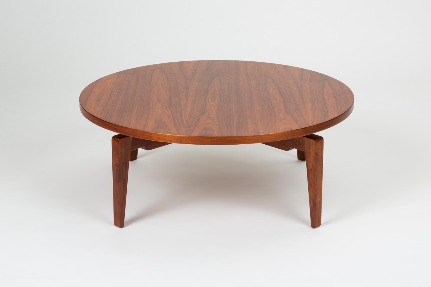A 1958 design for a large round walnut coffee table by the Danish-American Jens Risom for his company that rotates on a central mechanism for a “Lazy Susan” effect. There is a hidden wheel underneath the table that can be adjusted to increase