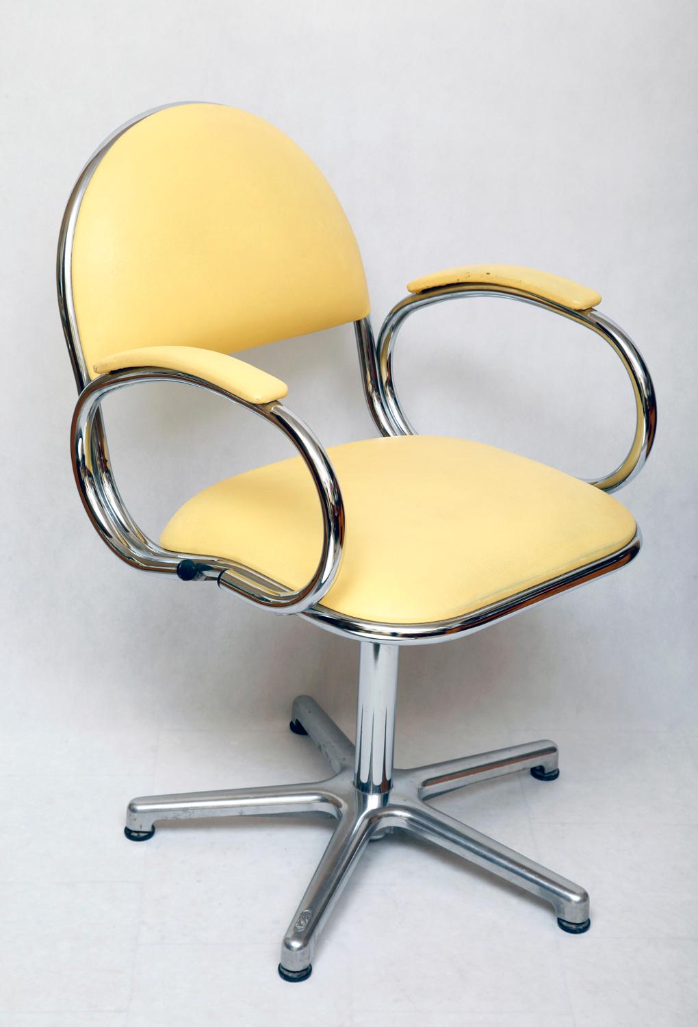 Vinyl yellow armchair with chrome backrests, not some sad contemporary. On one of the legs, the signature 