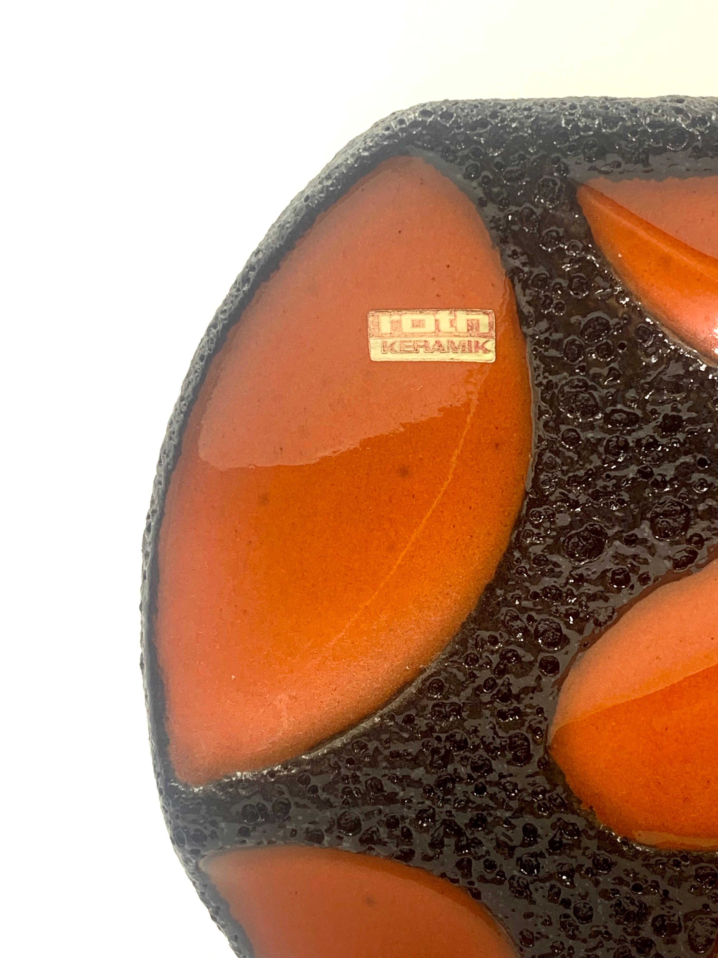 Eine Roth Keramic glänzend orange und schwarz lavaglasierte runde Vase.
Die Musternummer 310 und das Etikett des Folienherstellers sind erhalten.
In ausgezeichnetem Zustand aus den 1960er, 70er Jahren.