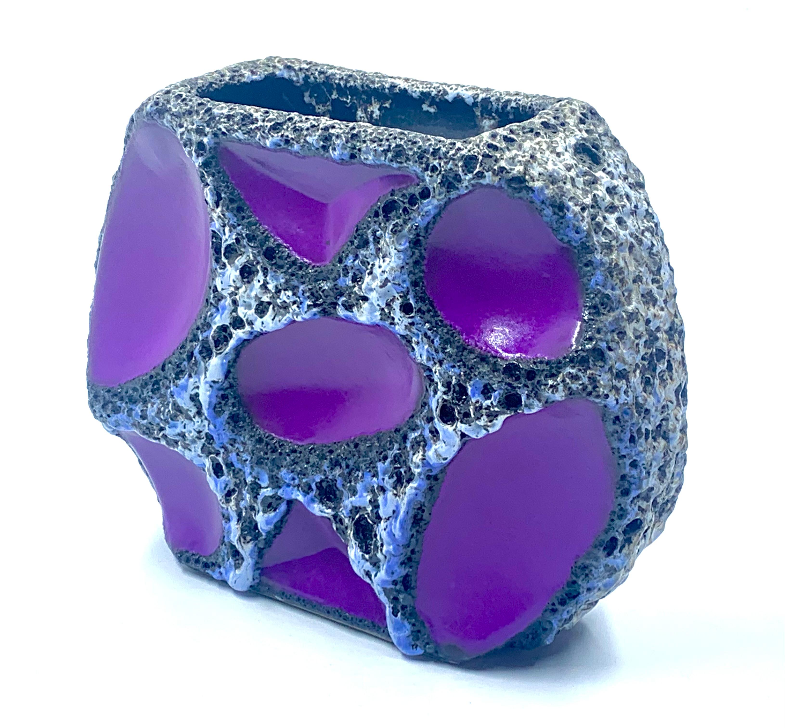Raro jarrón redondo plano de panel morado Roth Keramic, con bordes vidriados en lava blanca y negra y un anillo azul alrededor de cada segmento.
Patrón número 310, en excelente estado de los años 60-70.
