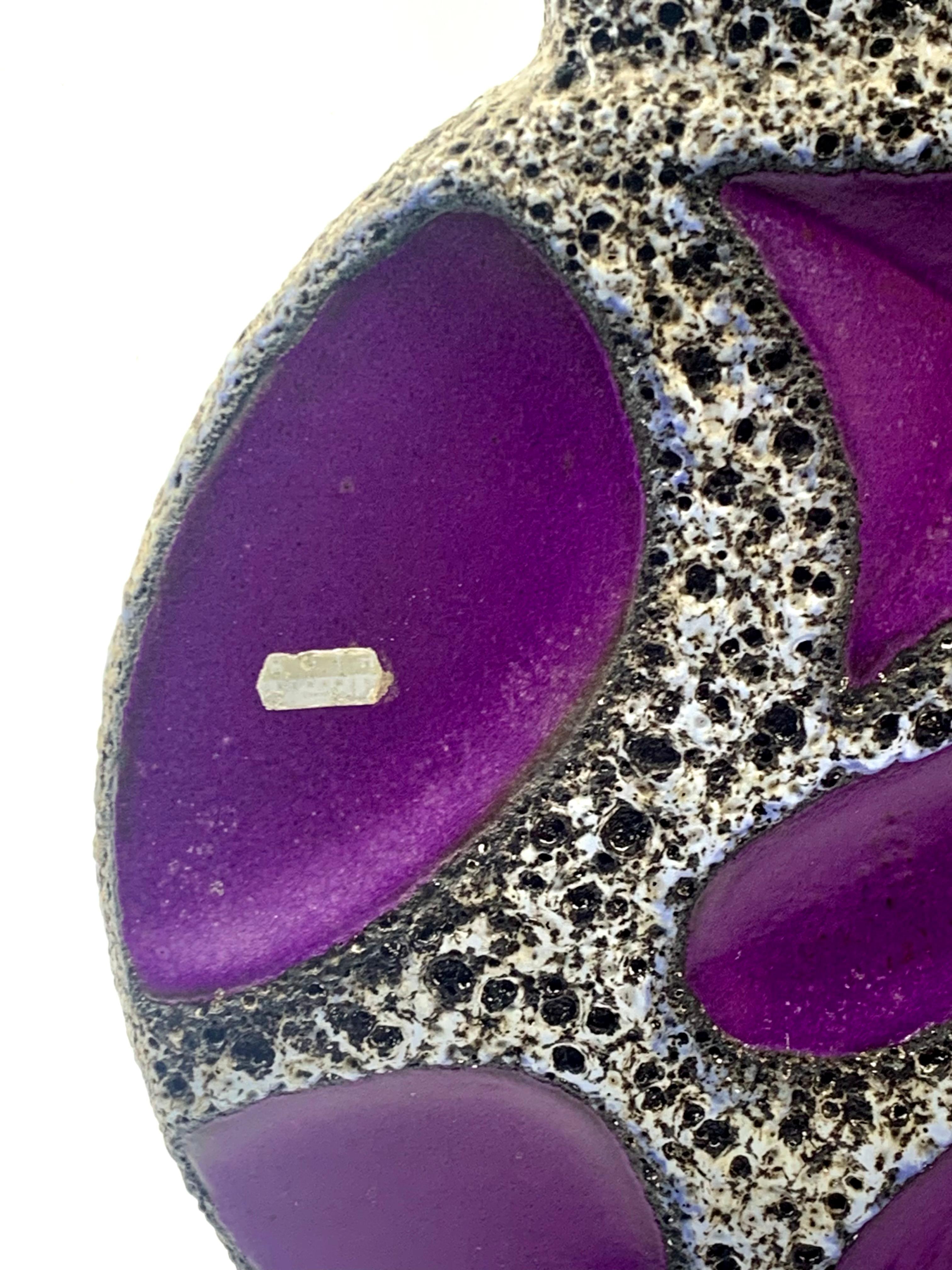 Jarrón Roth Keramik de 41 cm, con 2 asas anulares, de un raro color morado con vidriado de lava blanca y negra ribeteado de azul.
El morado es la única forma de color con este esmalte de lava, las otras 4 formas de color tienen un esmalte de lava