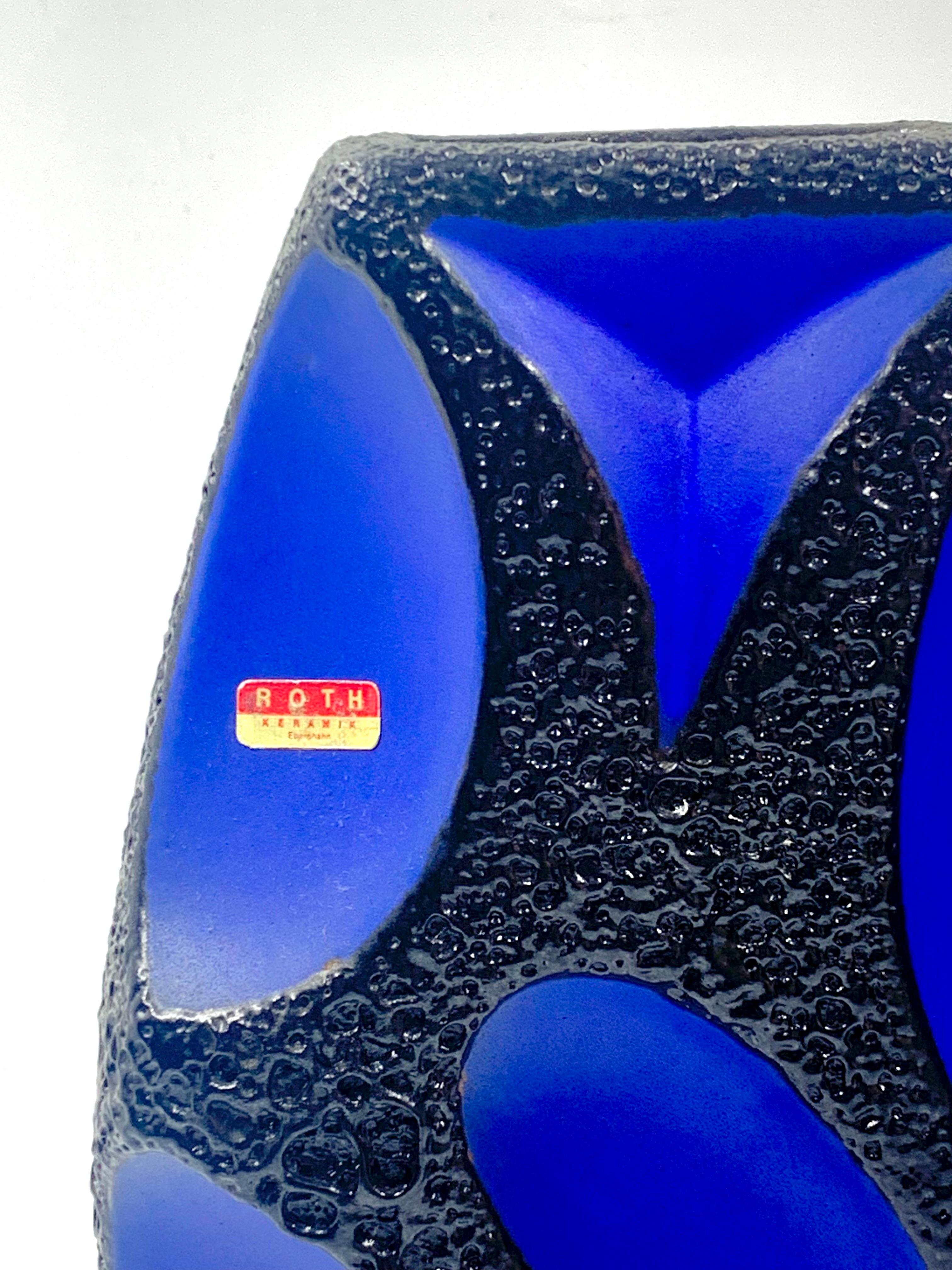 A Roth Keramik extremely rare blue panelled large vase with black lava glazed borders, pattern number 311.
In excellent condition, it retains the manufacturer’s foil label.
This lozenge shape was made in two sizes of which tis is the largest.