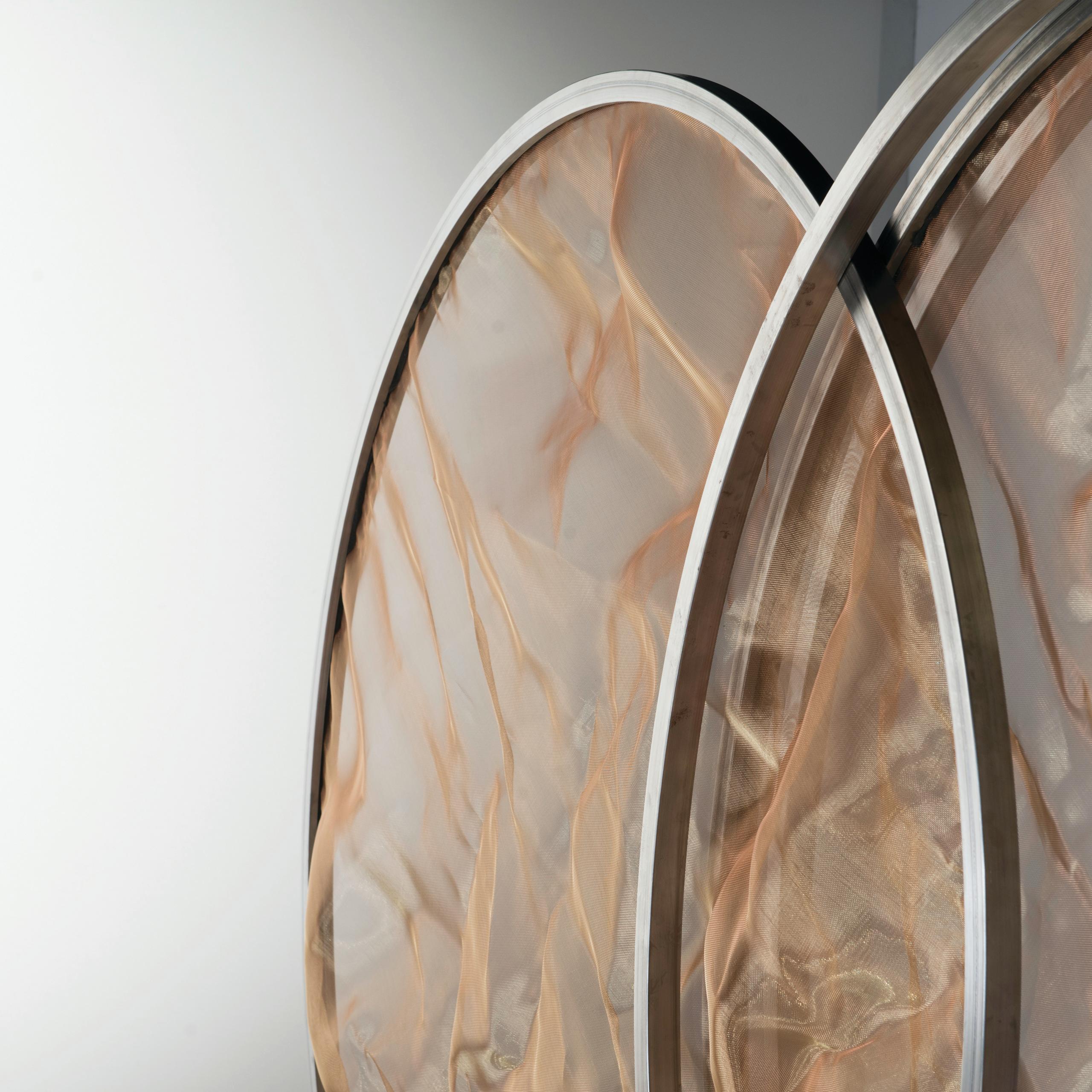 The rotO is a room divider composed of three circular elements that overlap and unfold by rolling. This rotational object creates a dynamic screen, or room divider, that plays with transparencies and materials. The rotO spins 360 degrees on its axis